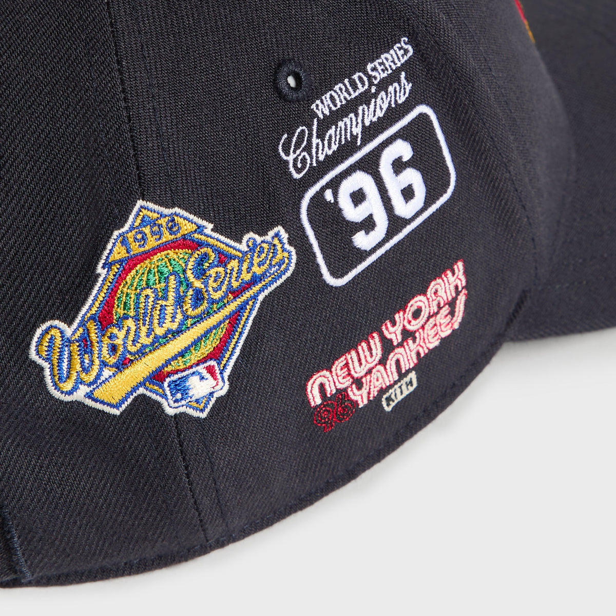 Detail of left-side patches: World Series diamond logo and New York Yankees script on Nocturnal cap