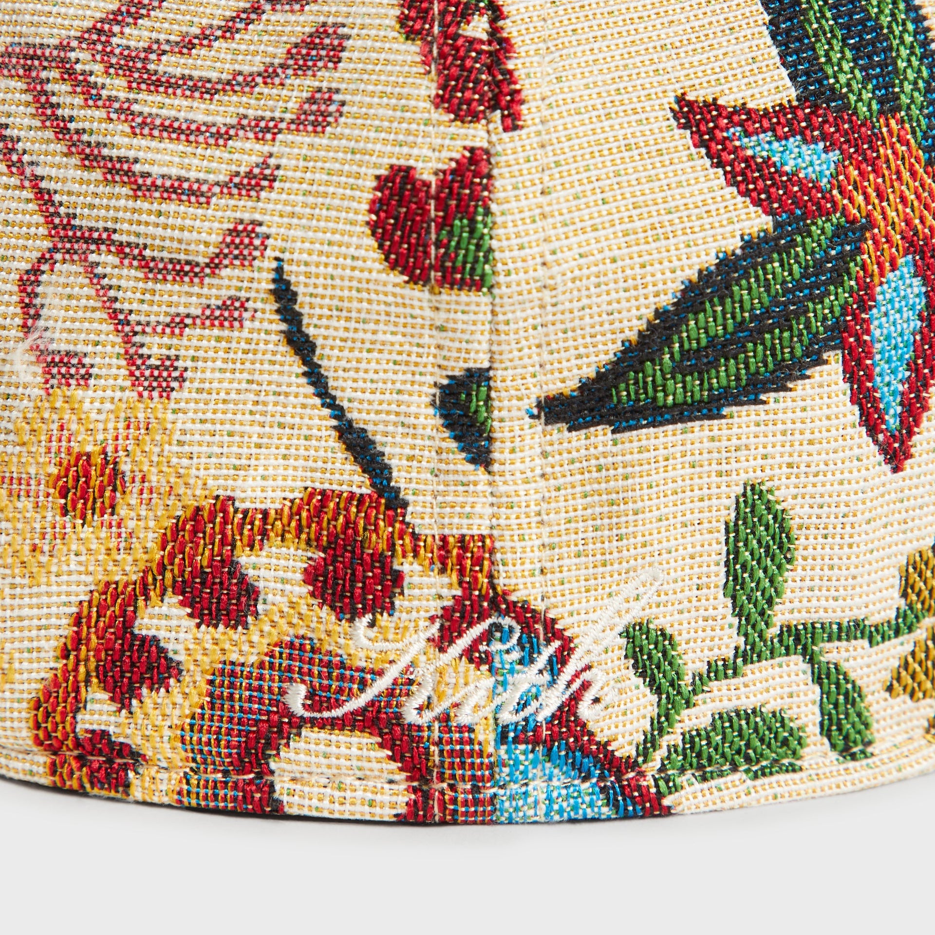 Close-up detail of floral tapestry pattern and cream Kith script embroidery near the back seam