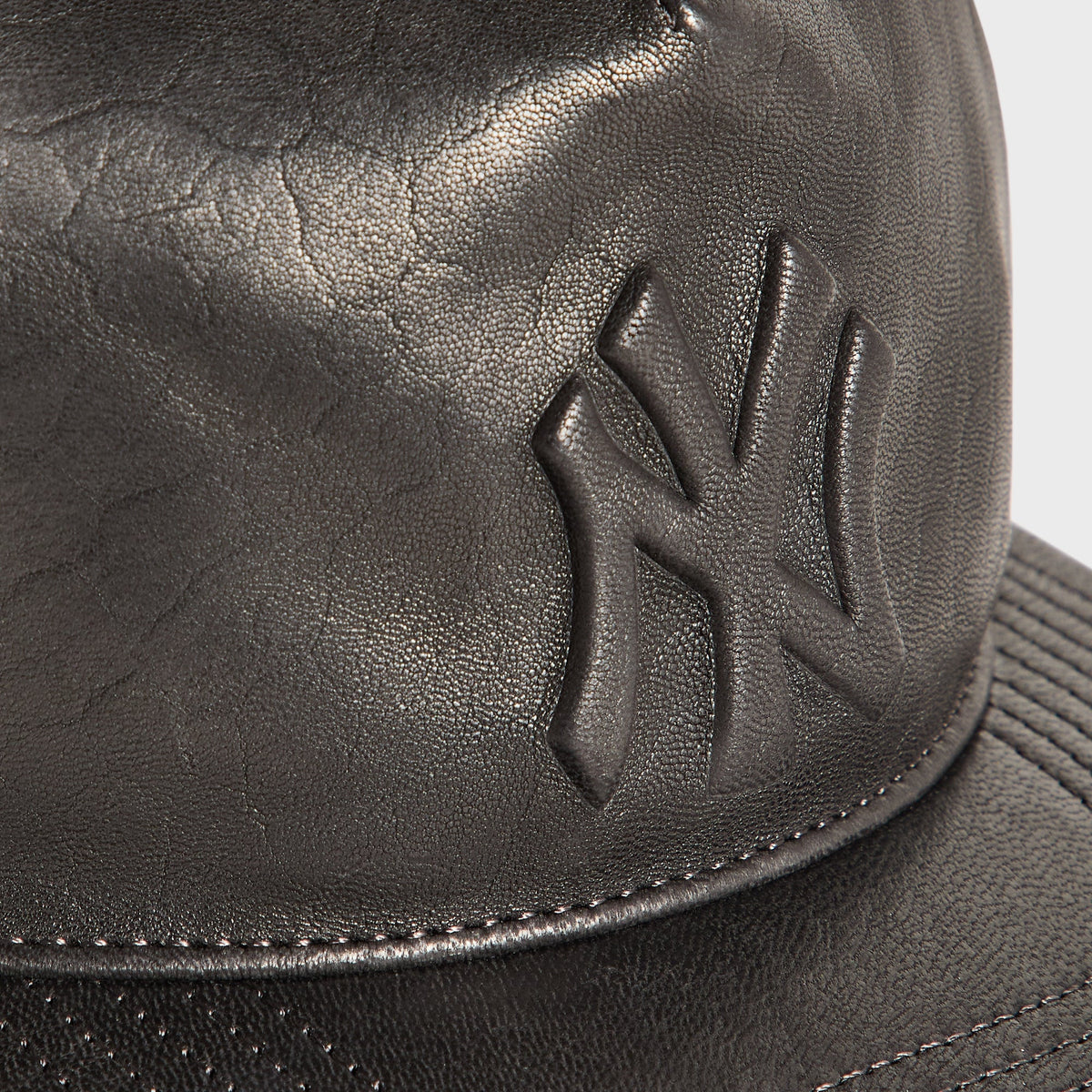 Close-up of embossed NY logo on the Giorgio Armani & Ronnie Fieg for '47 black soft leather Hitch cap