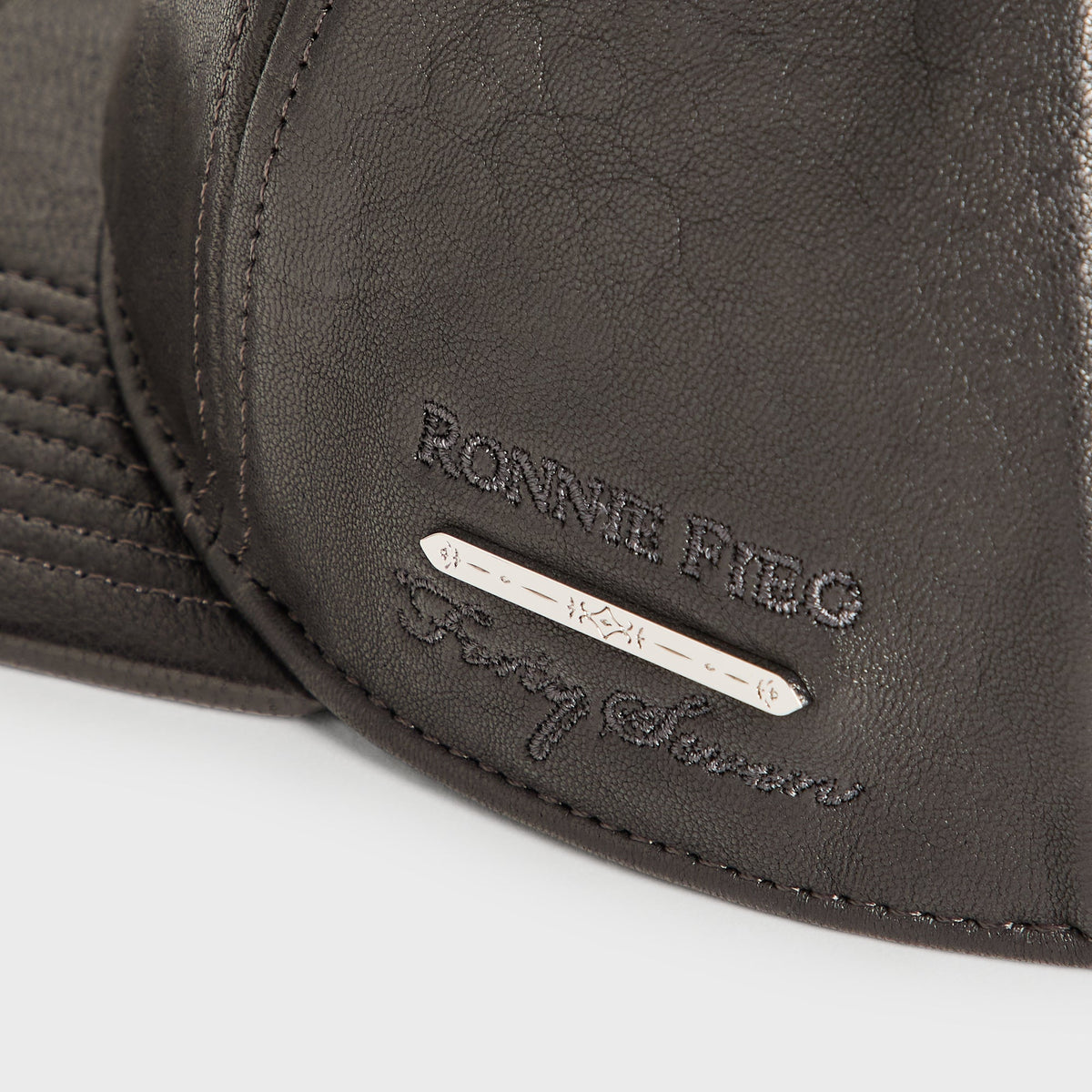 Close-up of Ronnie Fieg for Forty Seven metal bar tag on the Giorgio Armani black soft leather Hitch cap