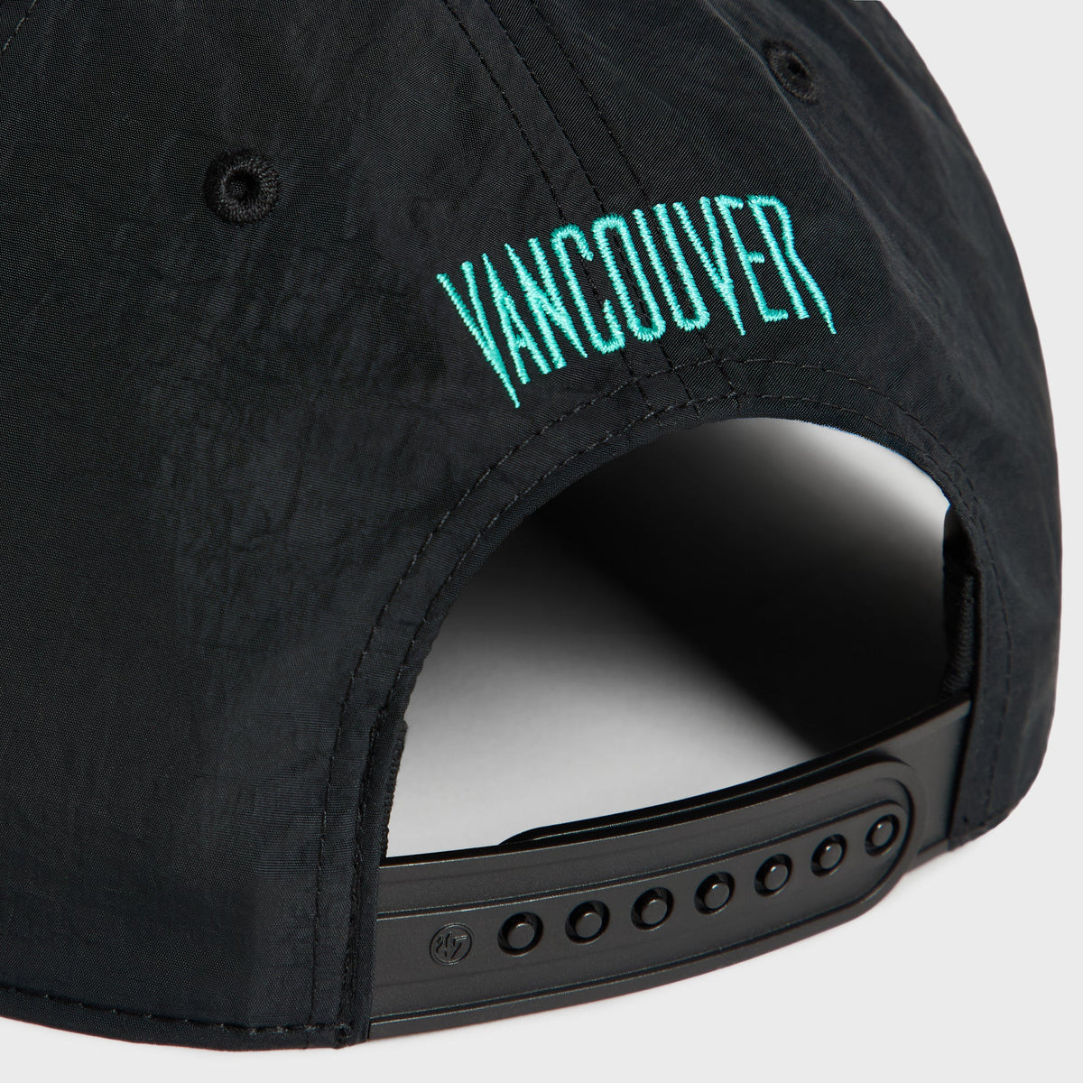 Close-up of teal Vancouver embroidery above the black snap closure on the back of the Kith & '47 Grizzlies cap