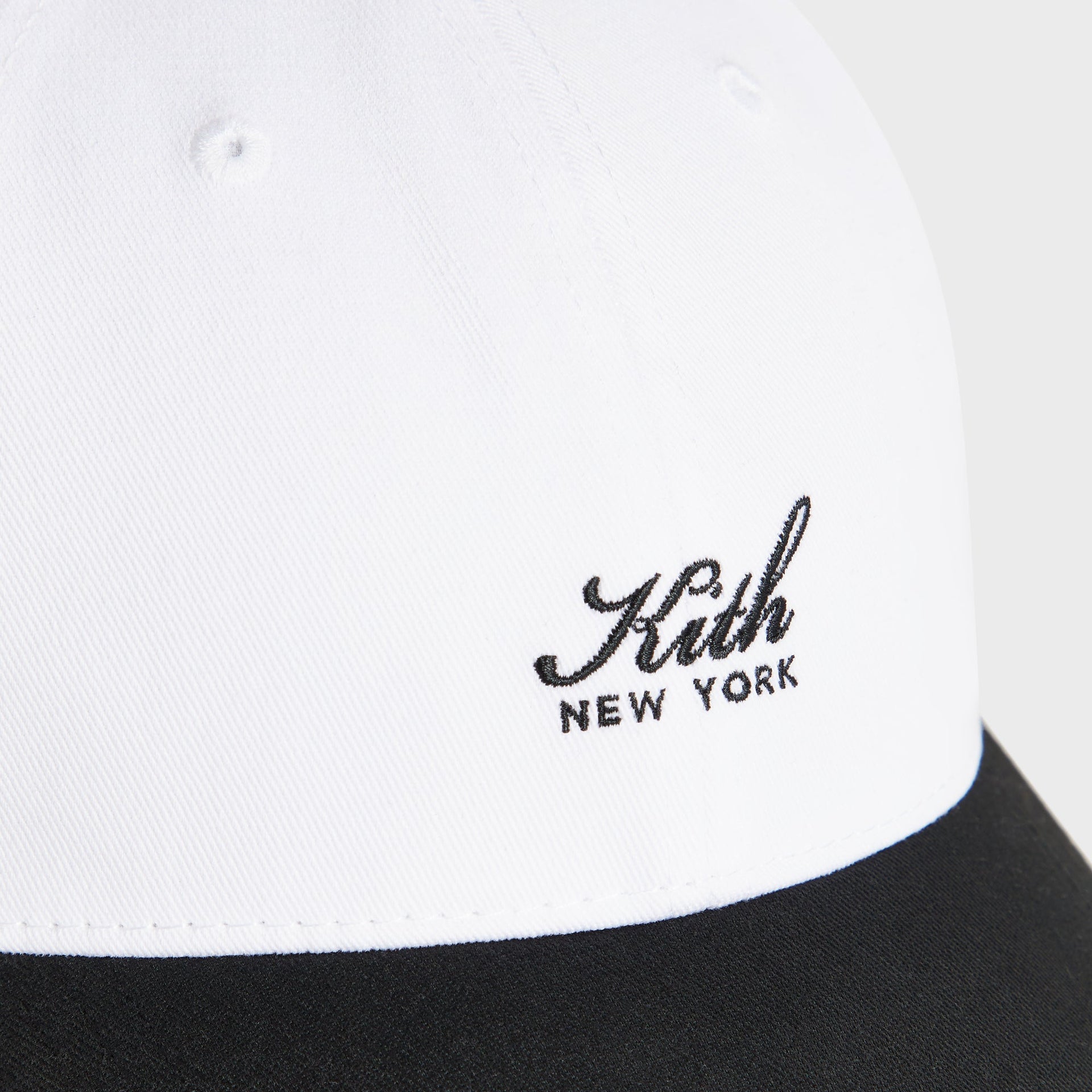 Close-up of the embroidered Kith New York script logo on the Two Tone classic cap