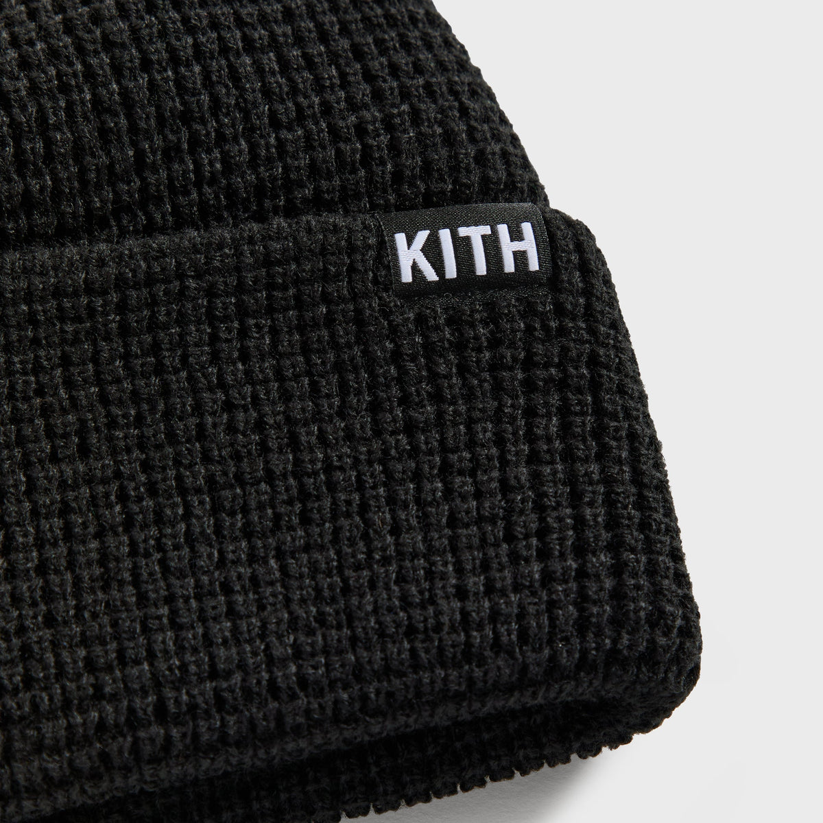 Close-up of white Kith box logo label on cuff of black waffle knit Kith & '47 Mets beanie