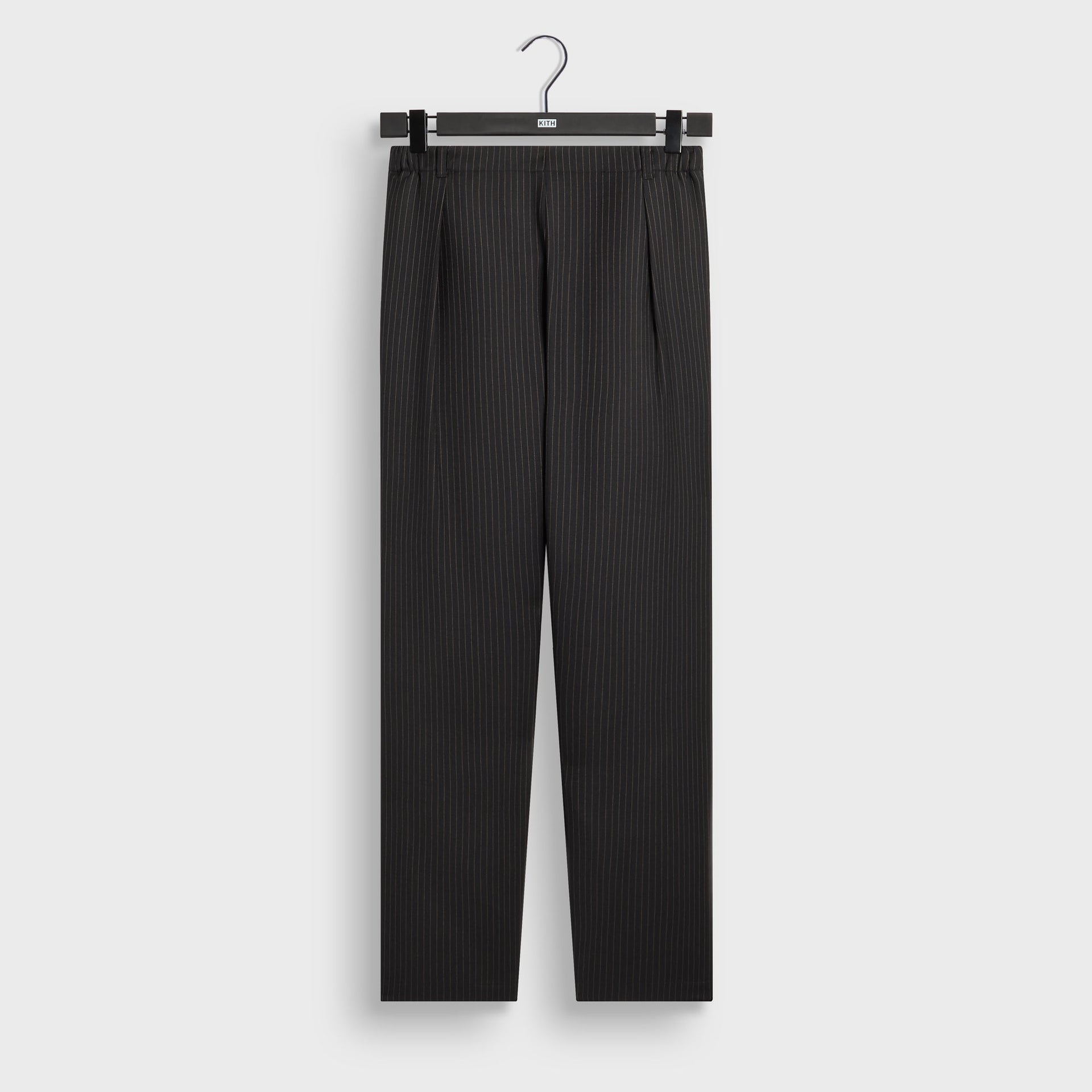 Kith Pinstripe Idris pant in black with tan pinstripe and pleated front, front flat lay