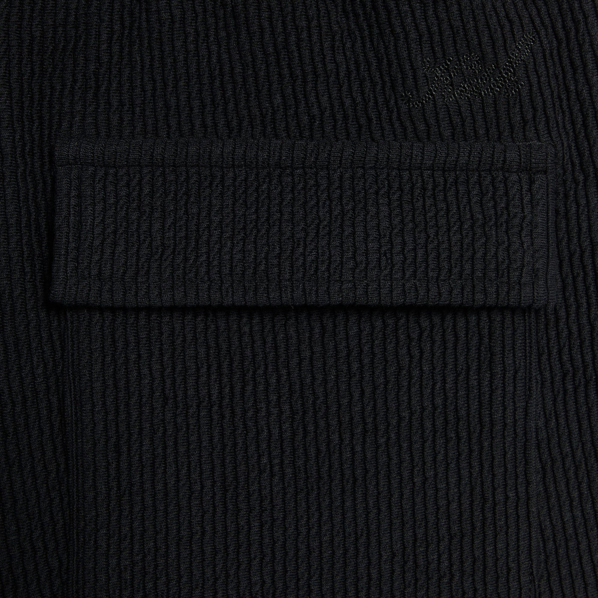Kith Heavy Crepe Elmhurst Pant, close-up of the back flap pocket and tonal embroidered logo on textured crepe