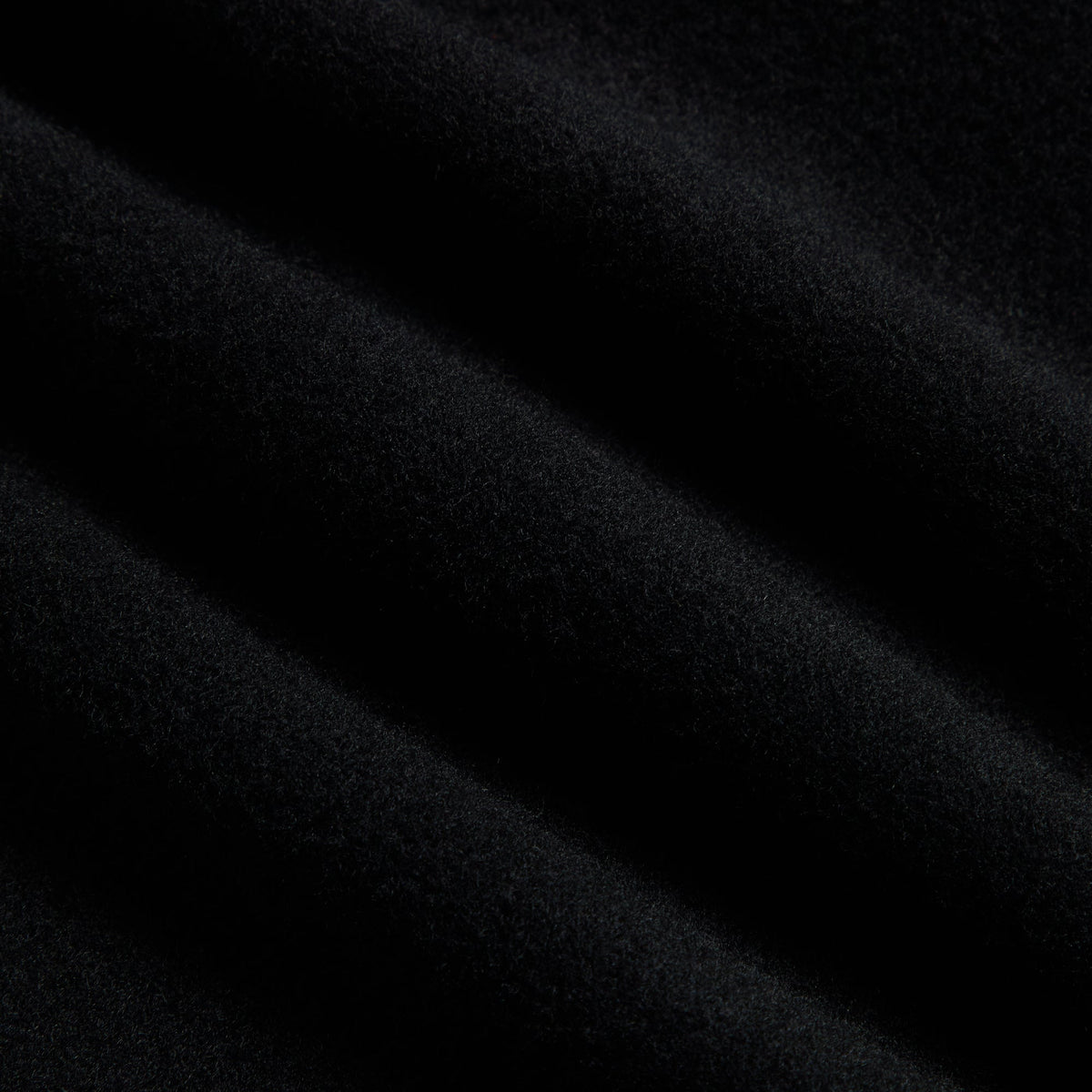 Close-up of black wool cashmere fabric of the &Kin Brett pleated trouser