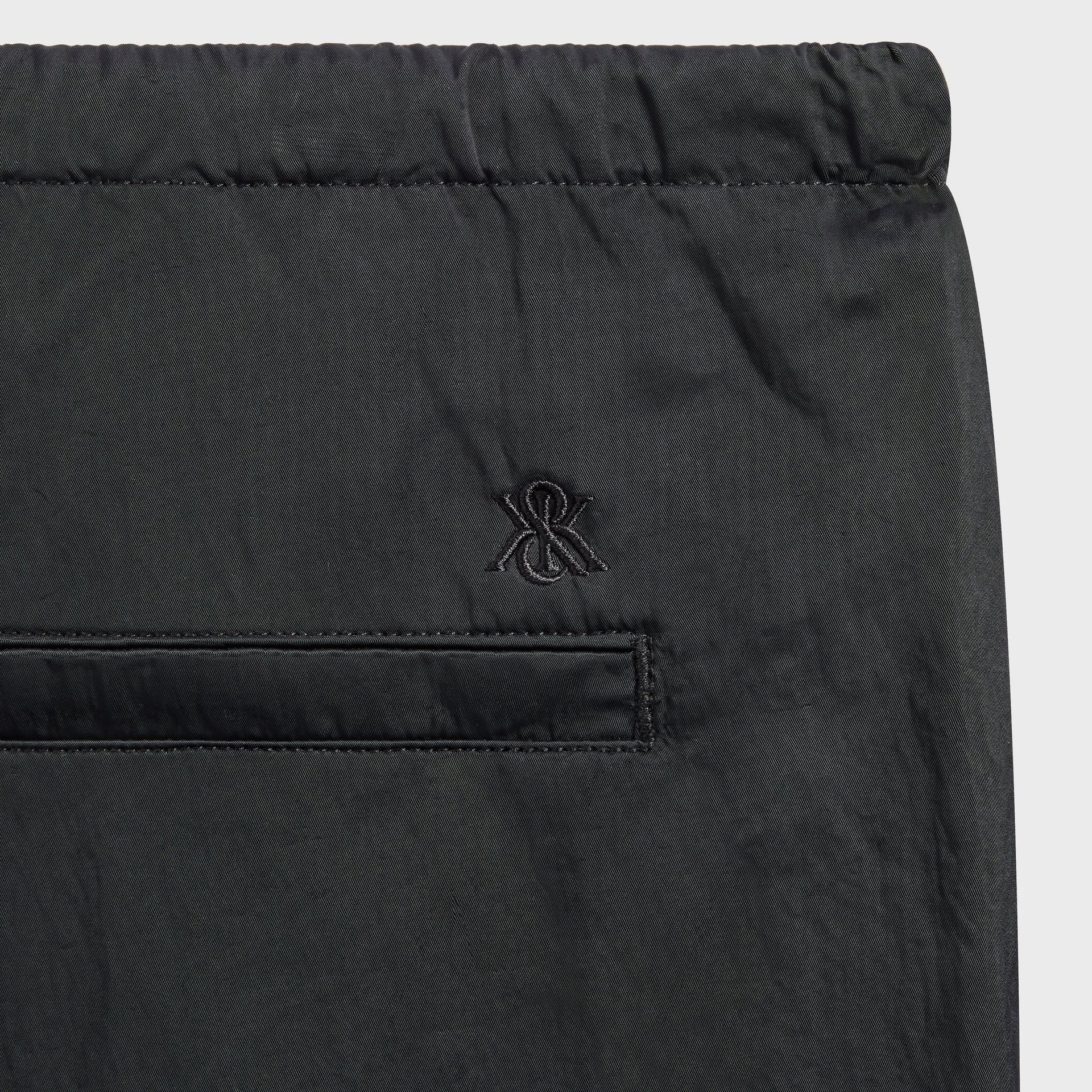 Close-up of the back pocket and embroidered ampersand logo on the Kith Nylon Maverick pant