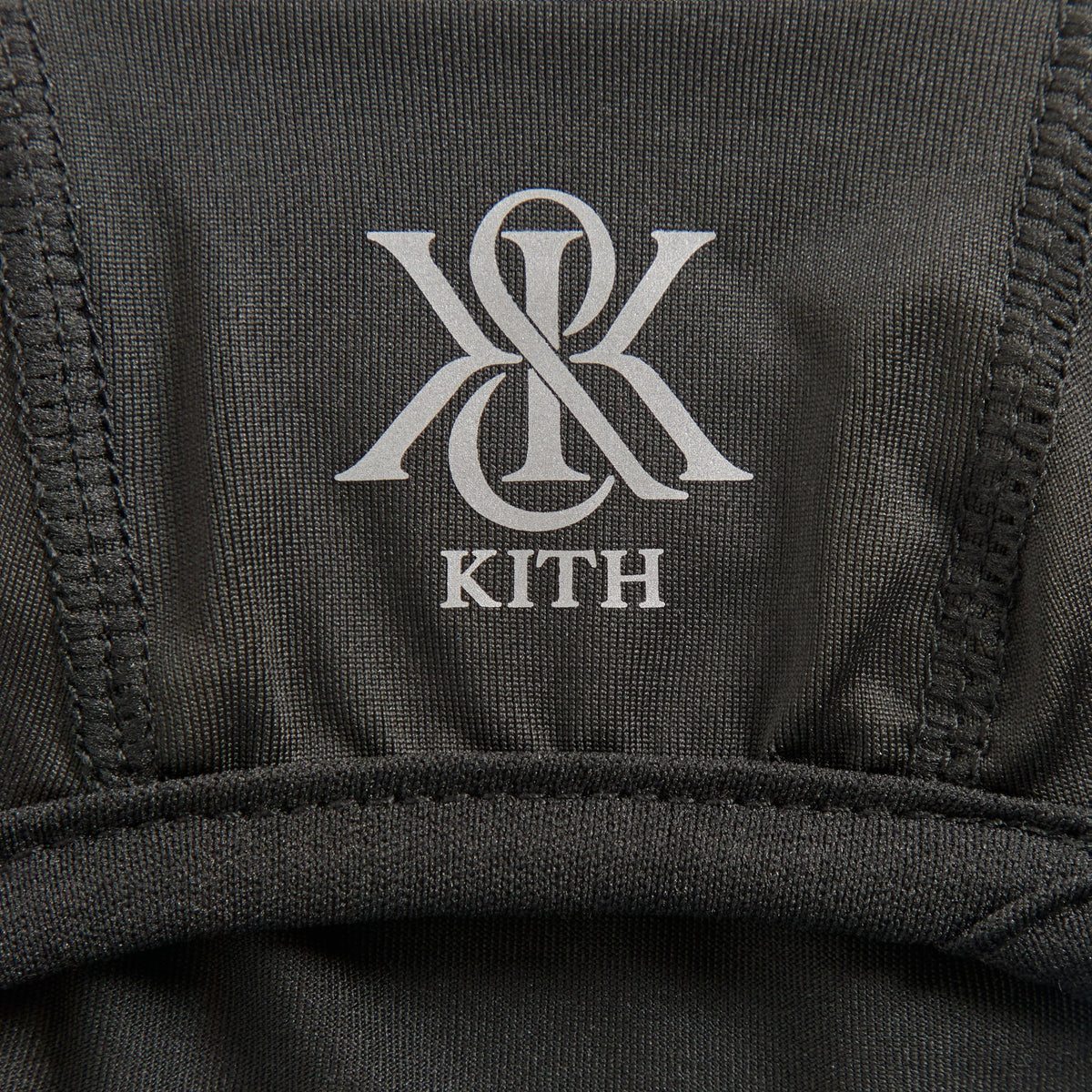 Close-up of the reflective Kith monogram logo printed on the crown of the balaclava