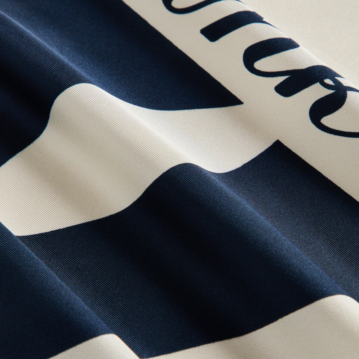 Close-up of the silk bandana's folds showing the Yankees script lettering and NY logo edge