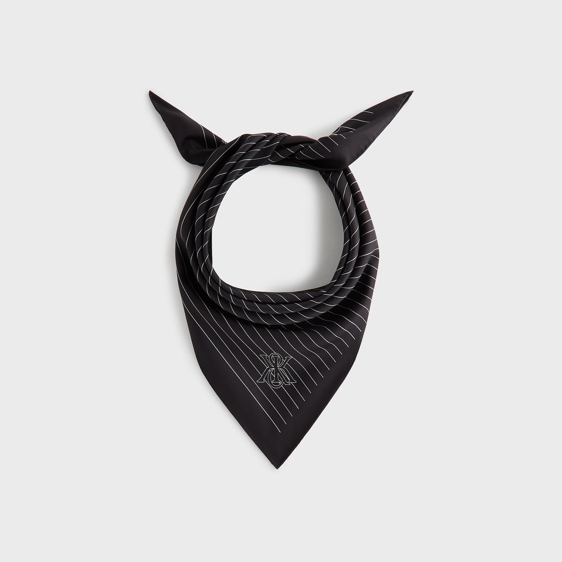 Kith Printed Silk Scarf in black pinstripe, styled tied as a neckerchief showing the Kith monogram at the point.