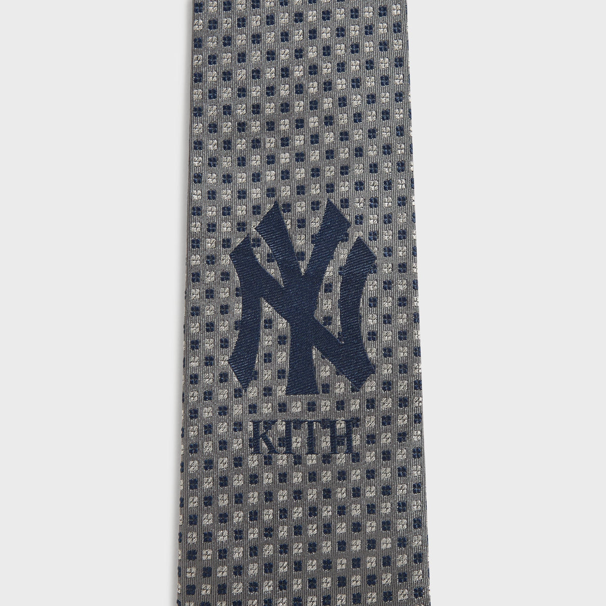 Close-up detail of grey dot foulard weave and NY Kith logo on Skyscraper tie