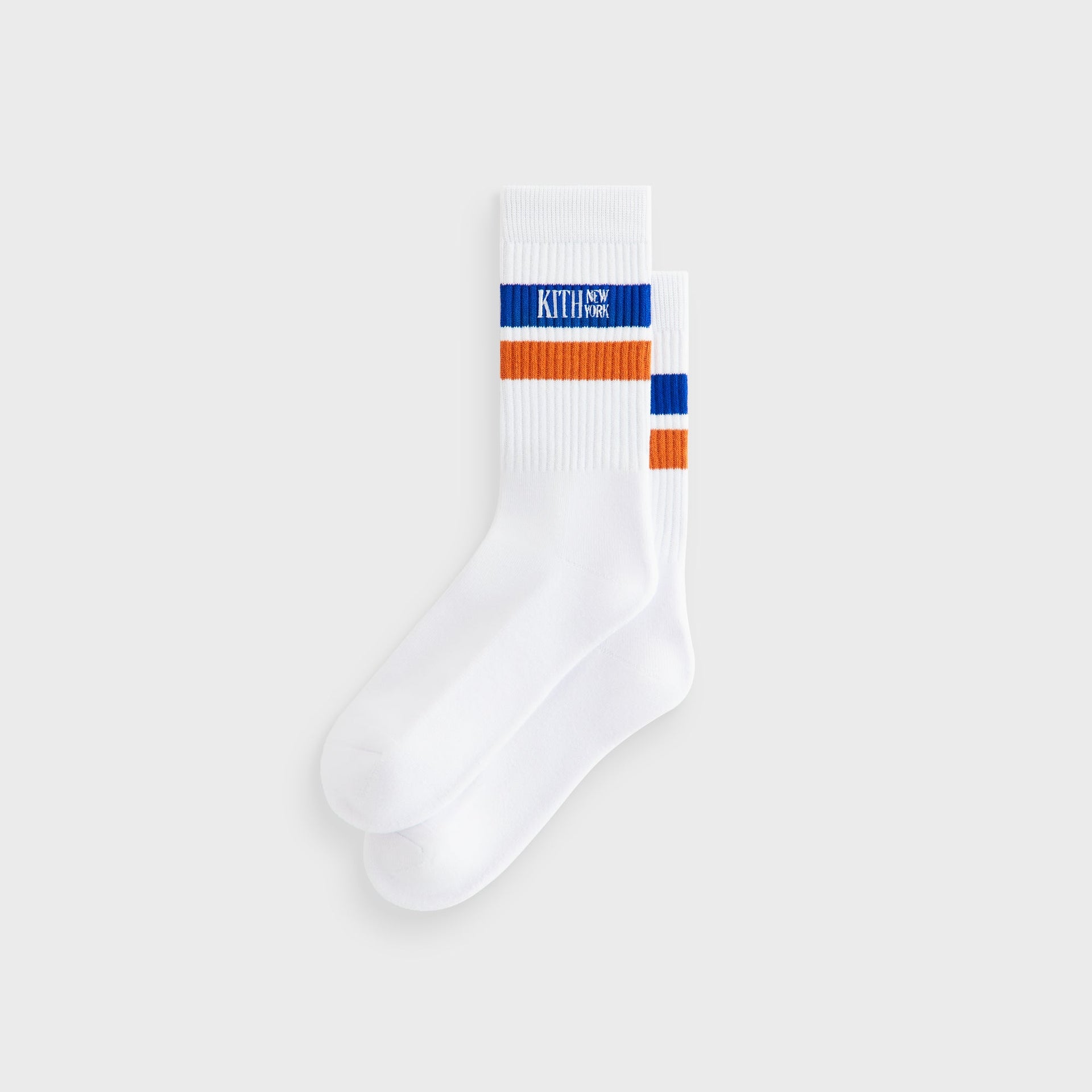 Kith Calf Stripe Socks in white with blue and orange stripes and Kith New York logo, flat lay pair