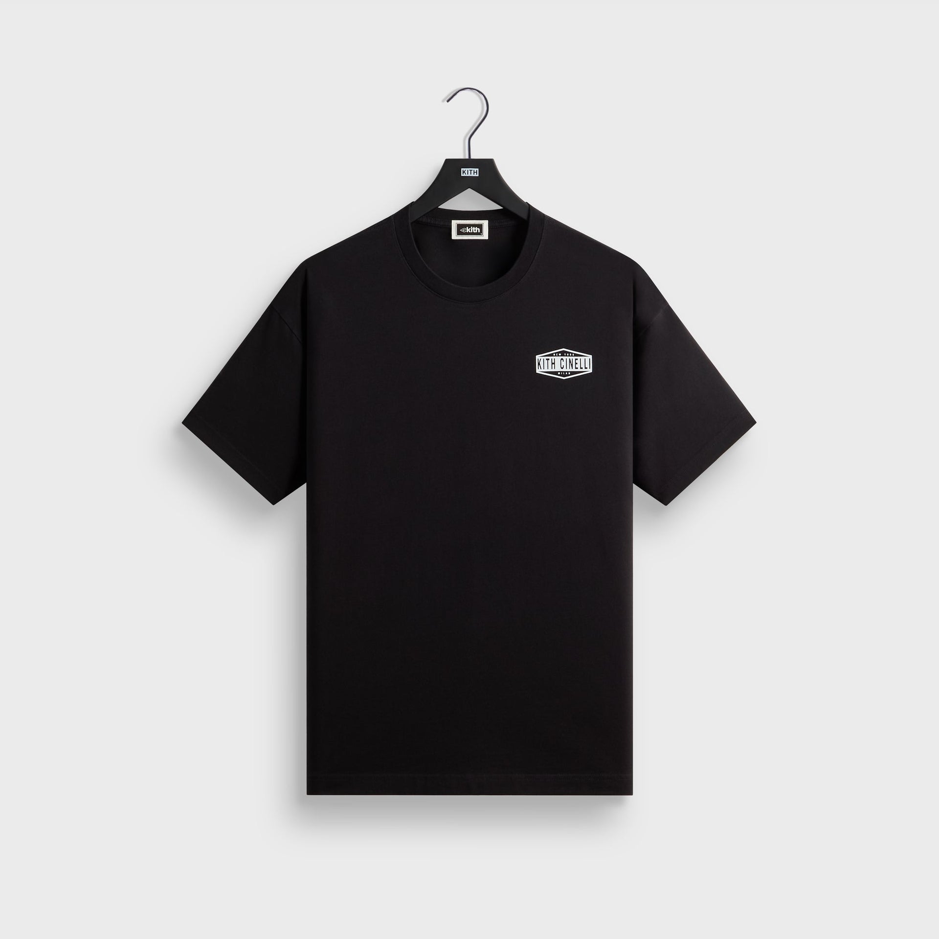 Front of the black Kith for Cinelli Ciclismo Tee on a Kith hanger with a small white hexagonal Kith Cinelli New York Milan chest badge