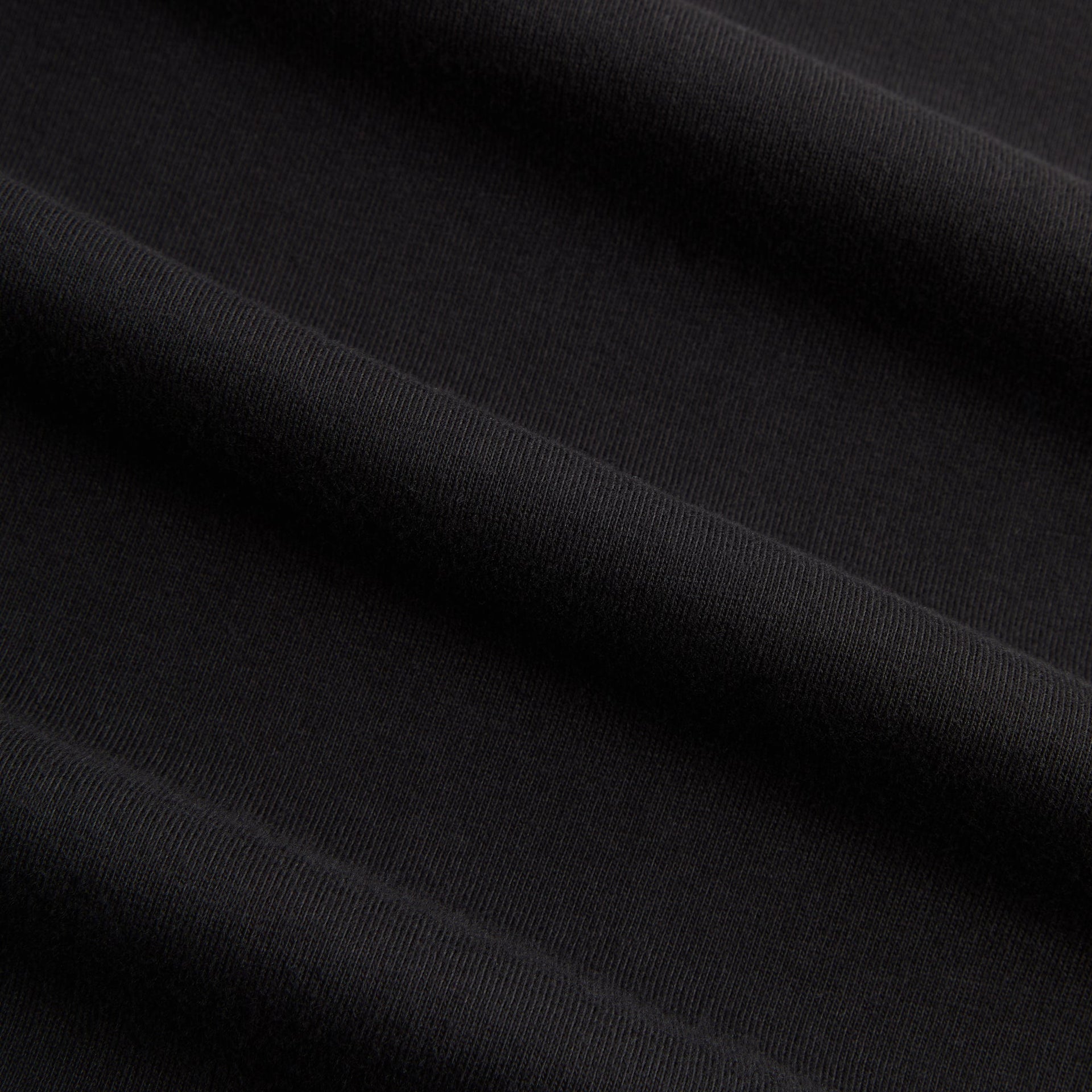 Kith for Cinelli Upside Down Tee in black, detail close-up of the soft black cotton jersey fabric texture.