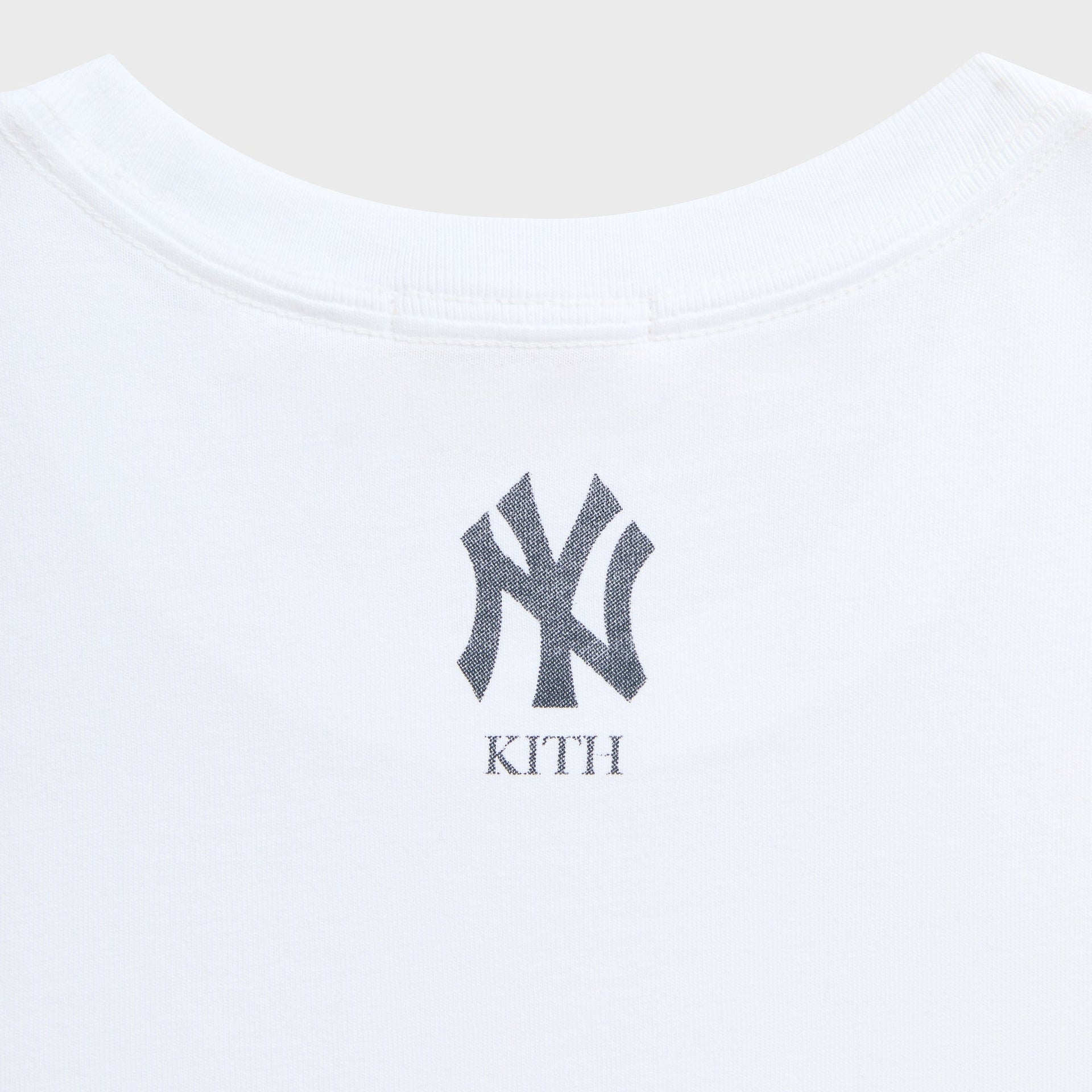 Close-up of NY Yankees and Kith logo print at the back neckline of white vintage tee