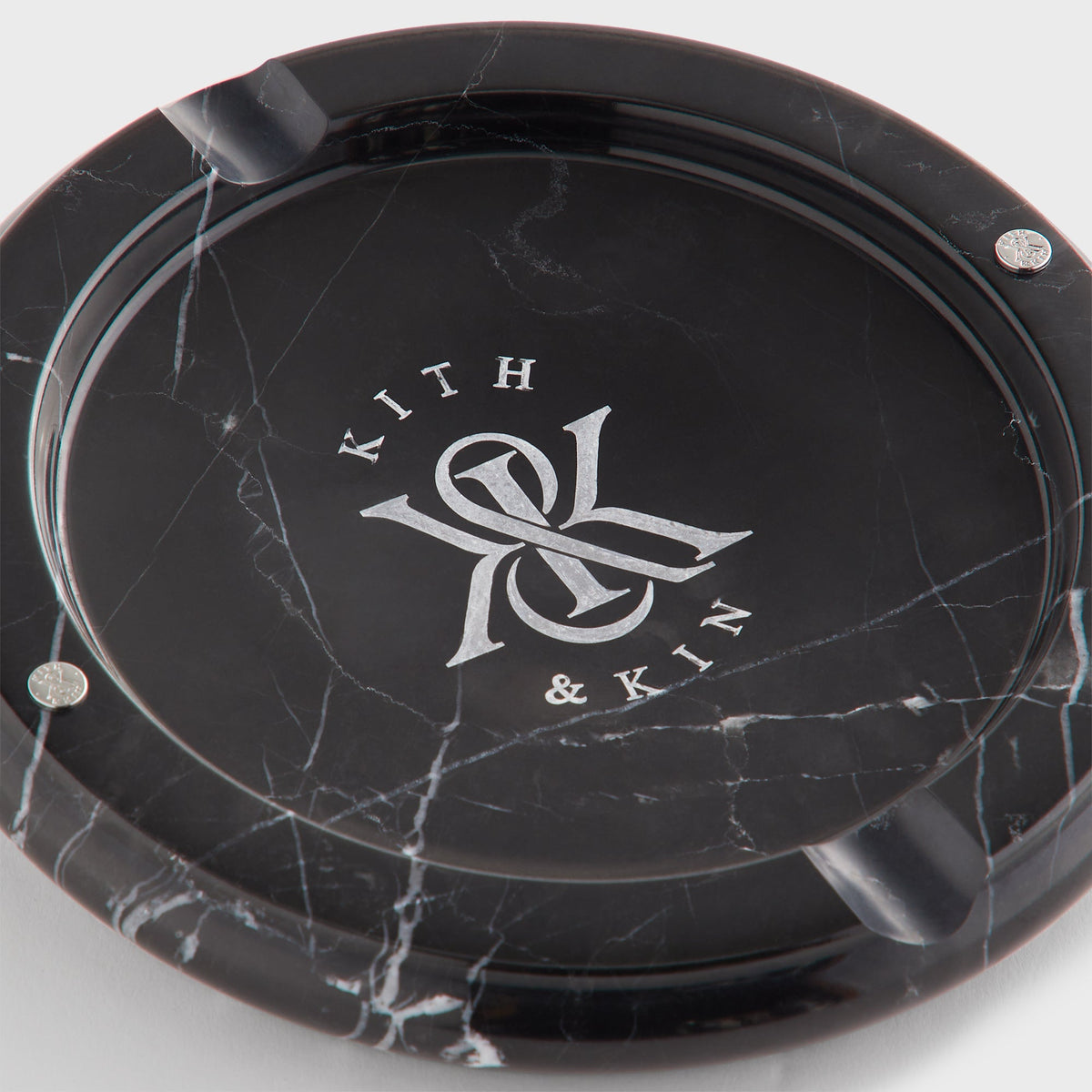 Close-up of Kith & Kin logo and white veining inside black marble catchall tray