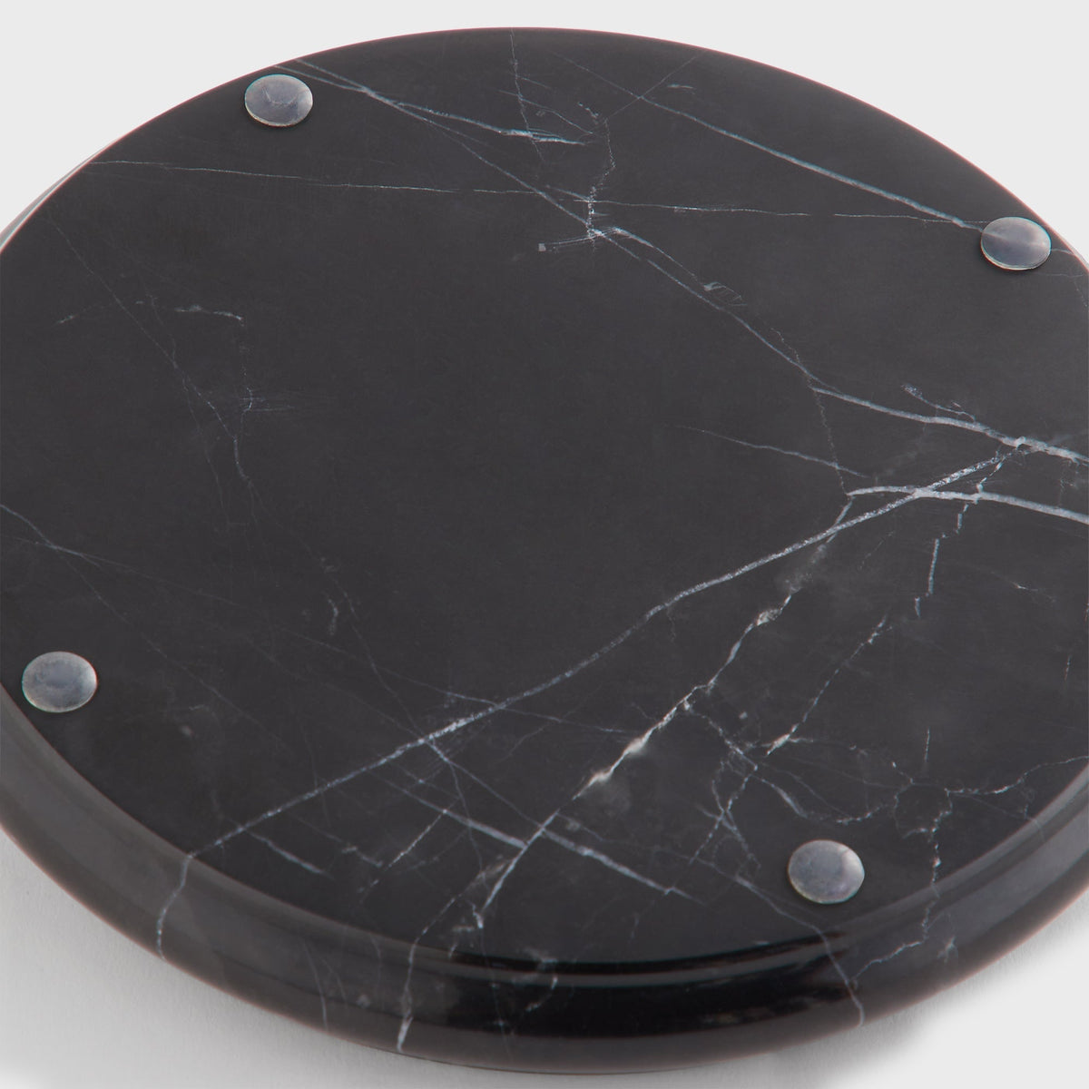 Close-up of the underside of the black Kith Marble Catchall Tray showing white marble veins and metal feet