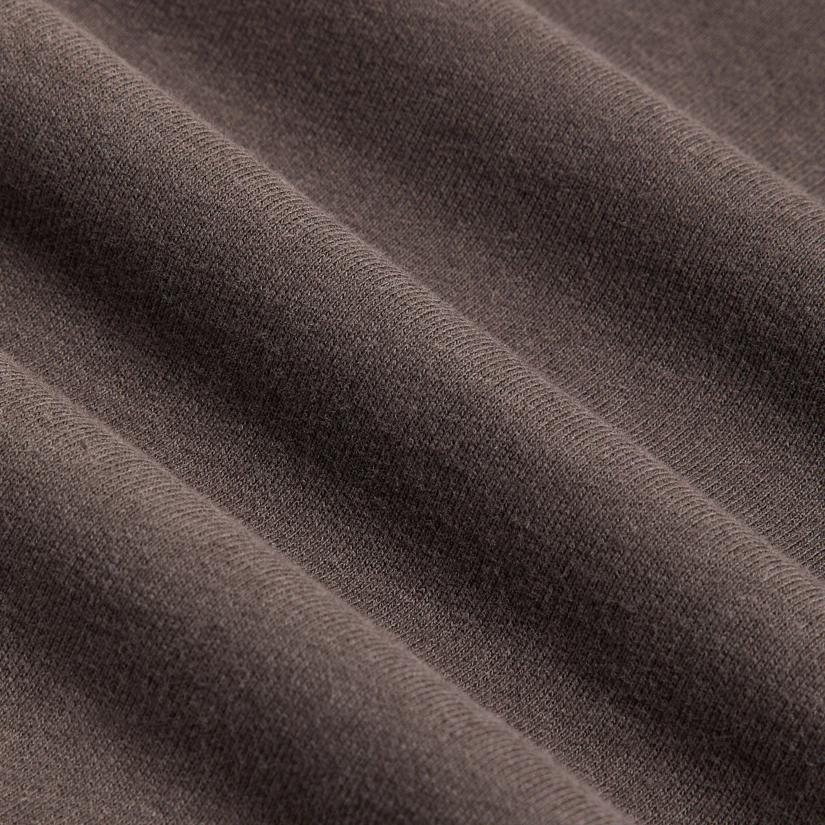 Fabric detail of Kith Treats Pumpkin Harvest Nelson Crewneck in Kindling, dark brown fleece-back cotton texture