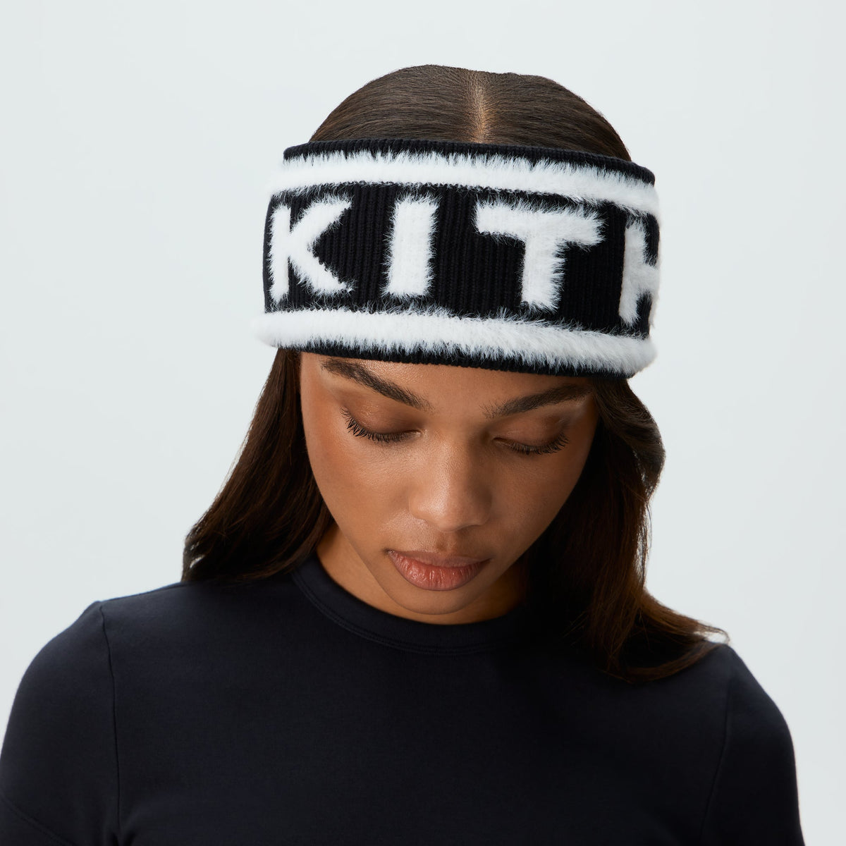 Model wearing the black Kith Jacquard Rib Headband with white 'KITH' logo, close front view