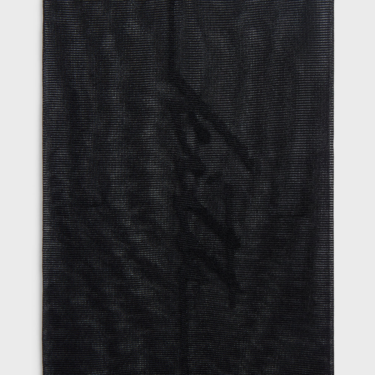 Close-up of the sheer mesh weave texture on the black Kith & Kin Line Tights