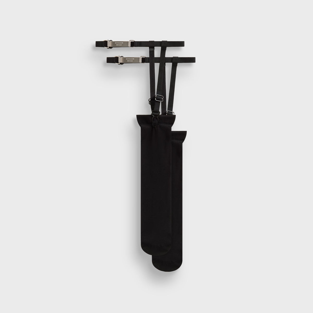 Kith Women Sheer Garter Belt Socks in black with silver 'Kith & Kin' branded garter clips, flat lay