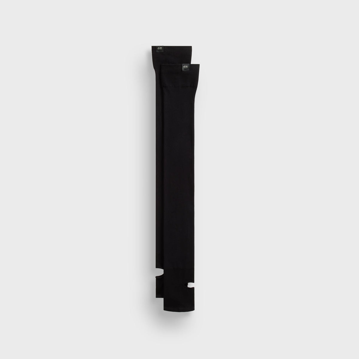 Kith Sheer Stirrup Thigh-High Socks in black with 'kith new york' woven labels, paired flat lay