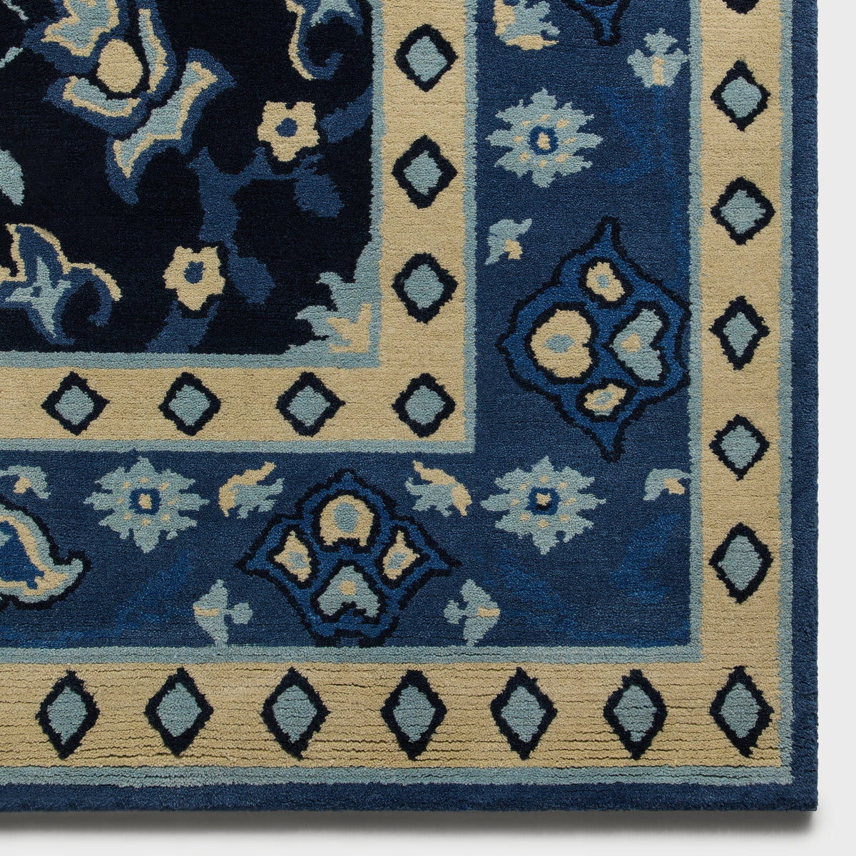 Corner detail of Nocturnal Kith x Yankees rug showing diamond trim border and floral medallion pattern