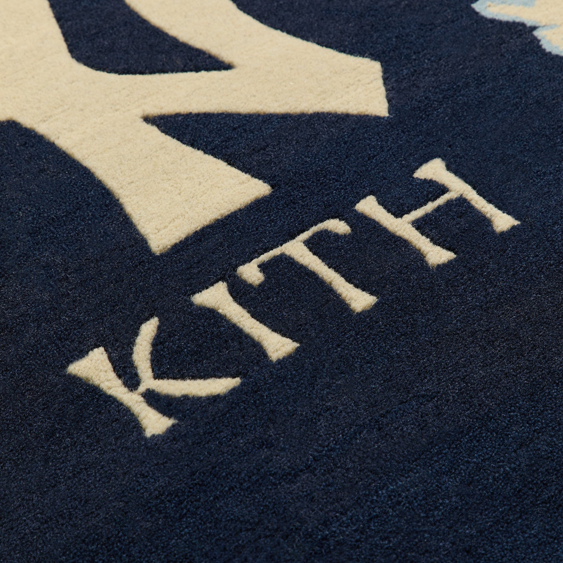 Macro detail of wool pile texture on KITH lettering, Nocturnal colorway Kith x Yankees hand-knotted rug