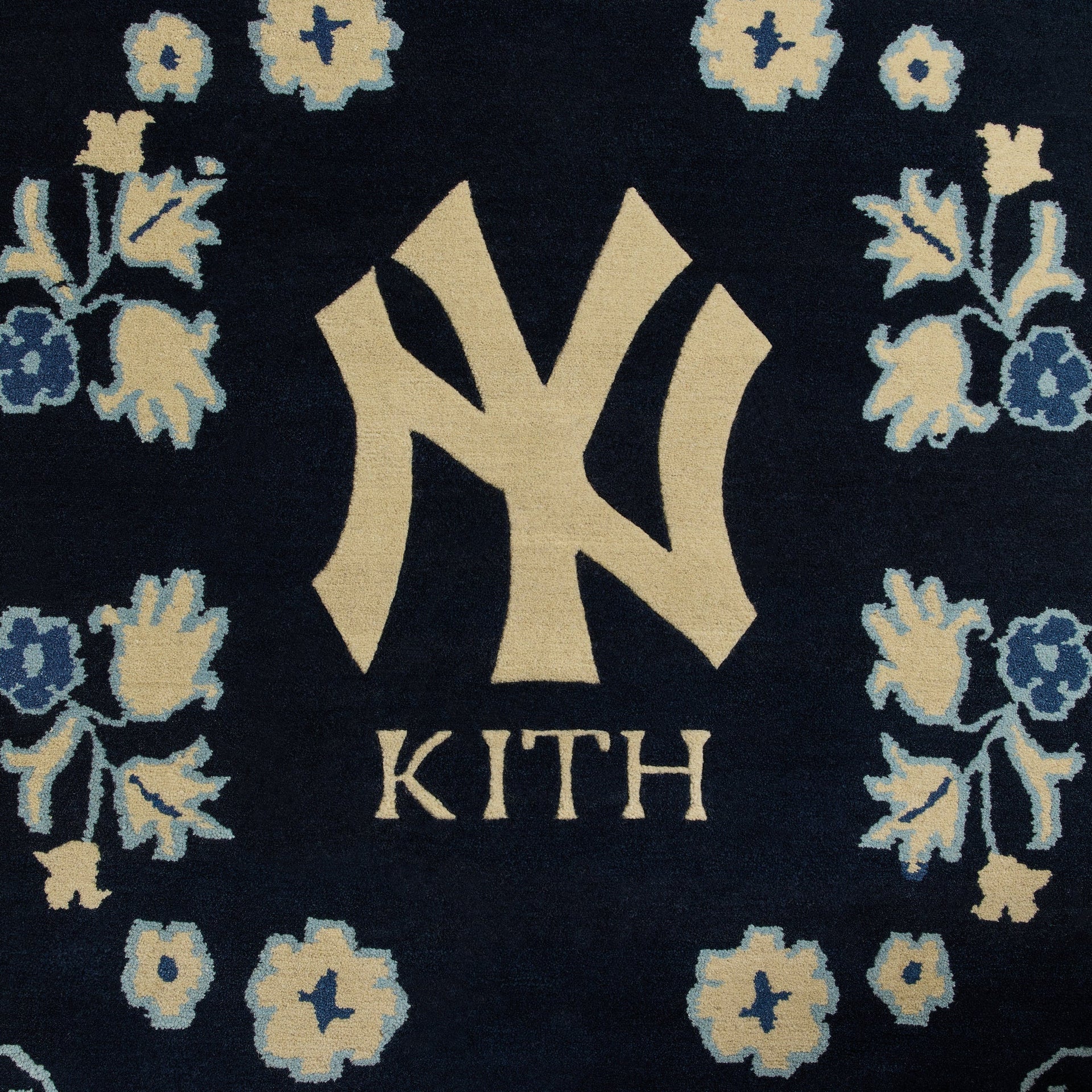 Close-up of center medallion on Nocturnal Kith x Yankees 5x8 rug showing tufted NY logo and KITH wordmark