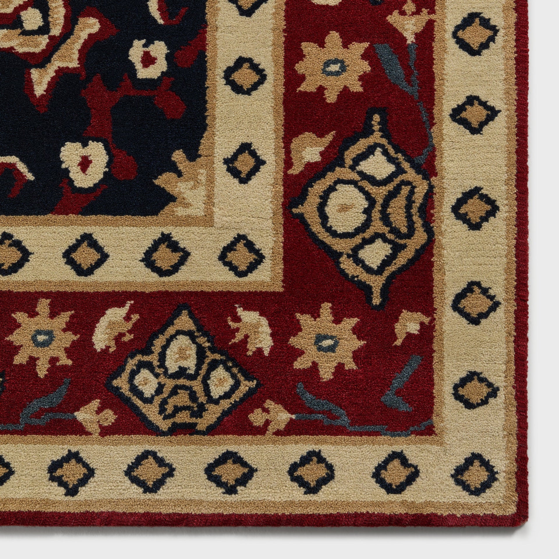 Corner detail of Multi colorway Kith x Yankees rug showing red diamond trim border and floral medallion pattern