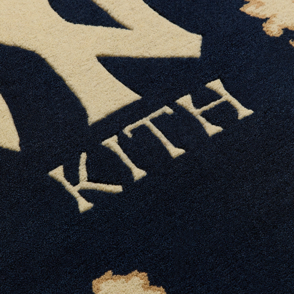 Macro detail of wool pile texture on KITH lettering, Multi colorway Kith x Yankees hand-knotted rug