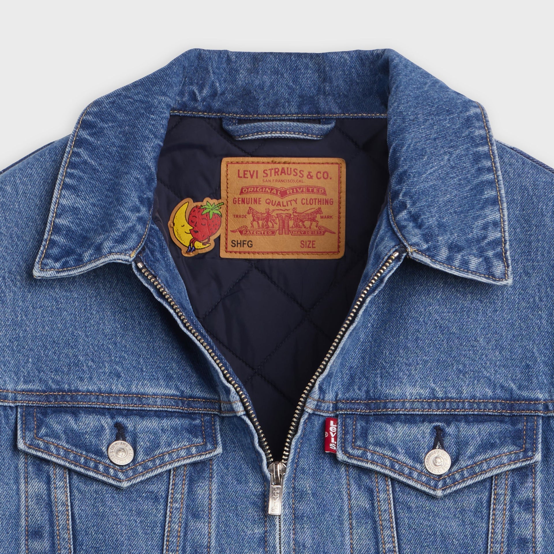 Collar detail of Levi's x Sky High Farm trucker jacket with silver zip, quilted navy lining and 'SHFG' Genuine Quality label