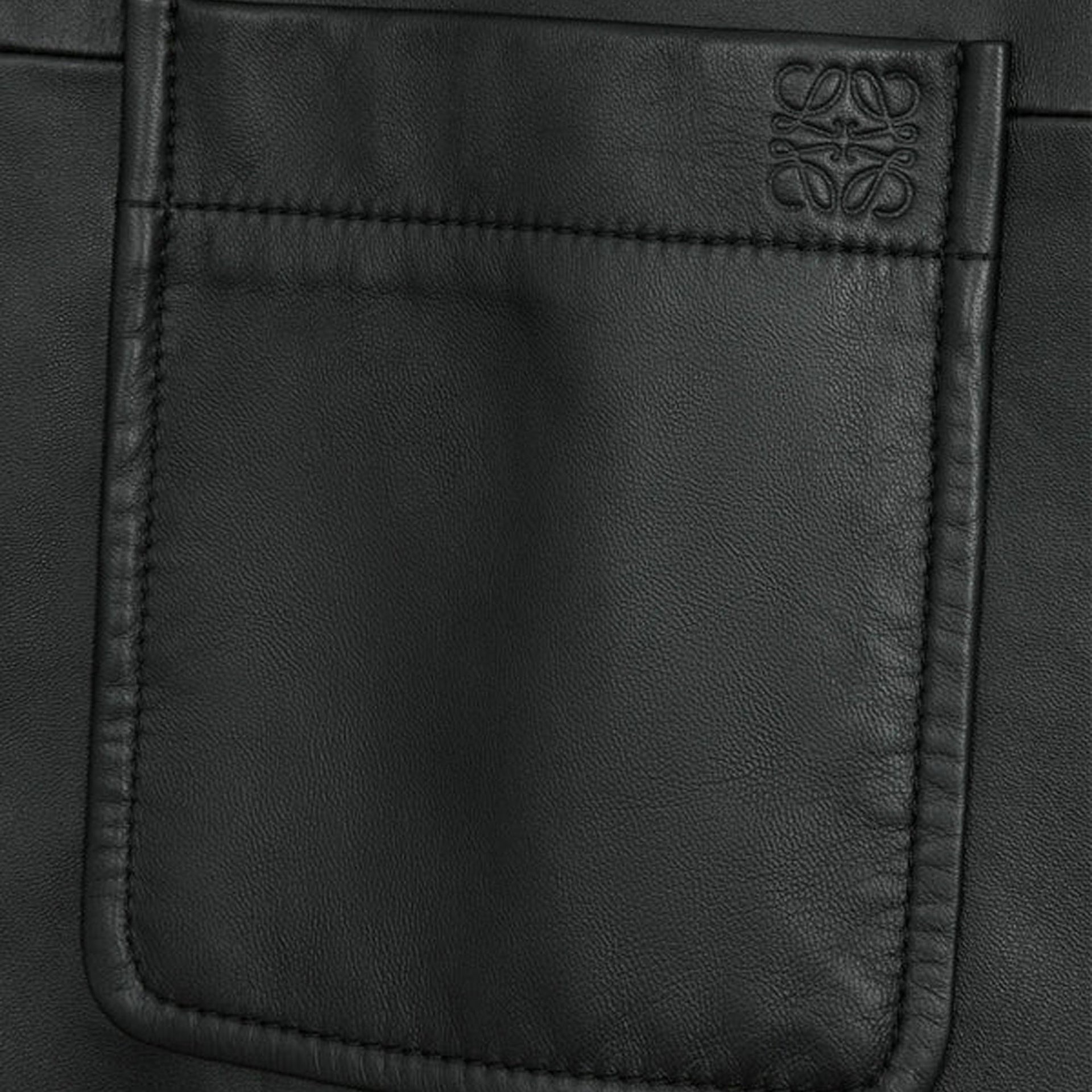 Close-up of embossed Anagram on the black nappa lambskin overshirt chest pocket