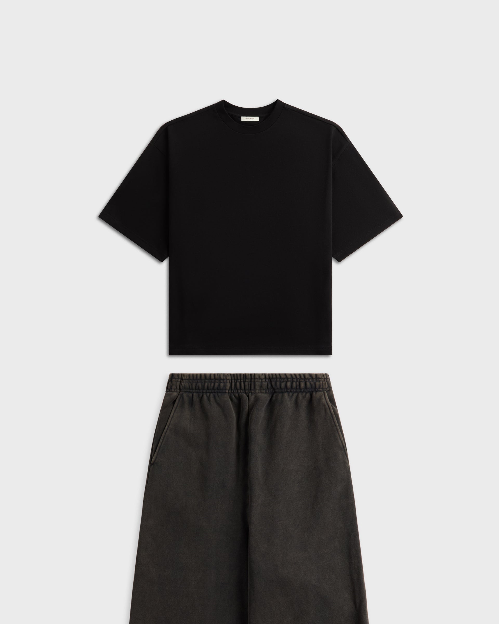 Entire Studios black oversized T-shirt and grey wide-leg shorts co-ord set, flat lay on white background