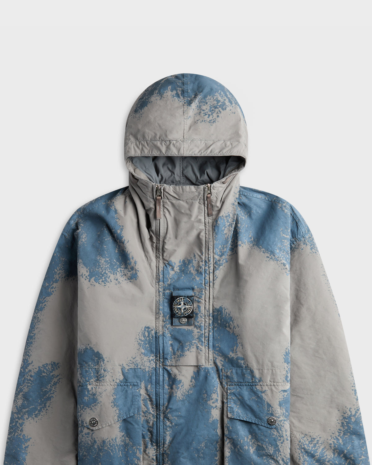 Stone Island grey and blue camouflage-print hooded jacket with logo patch, close-up front view