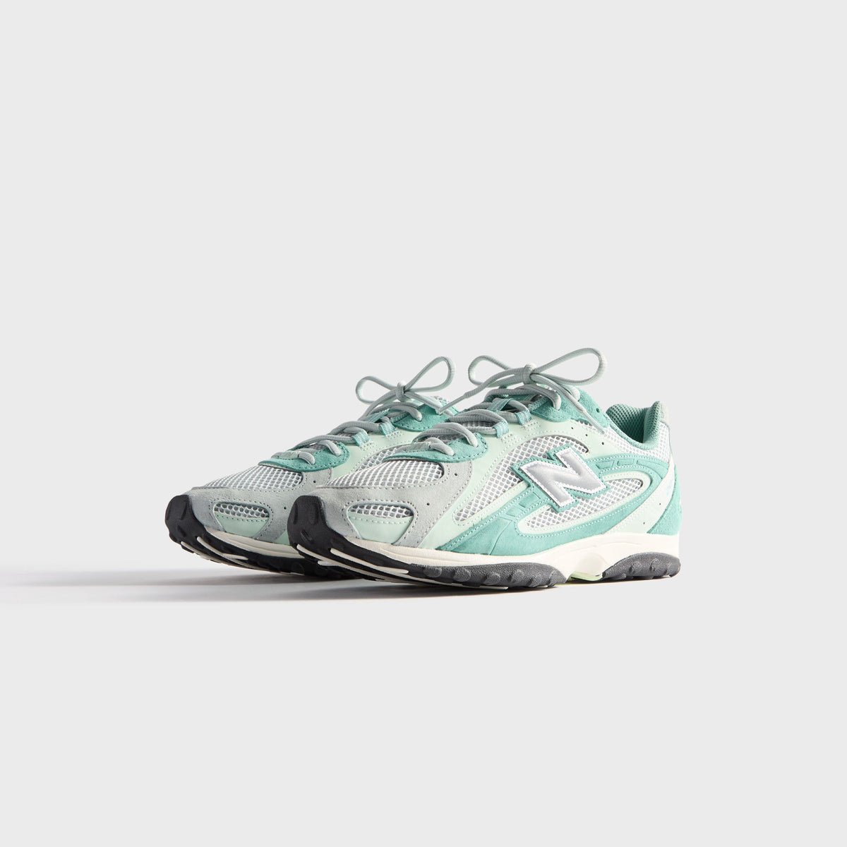 Kith & New Balance 204L in Bluebell, front three-quarter view of the pair showing mesh toe panels, grey suede and silver N logos