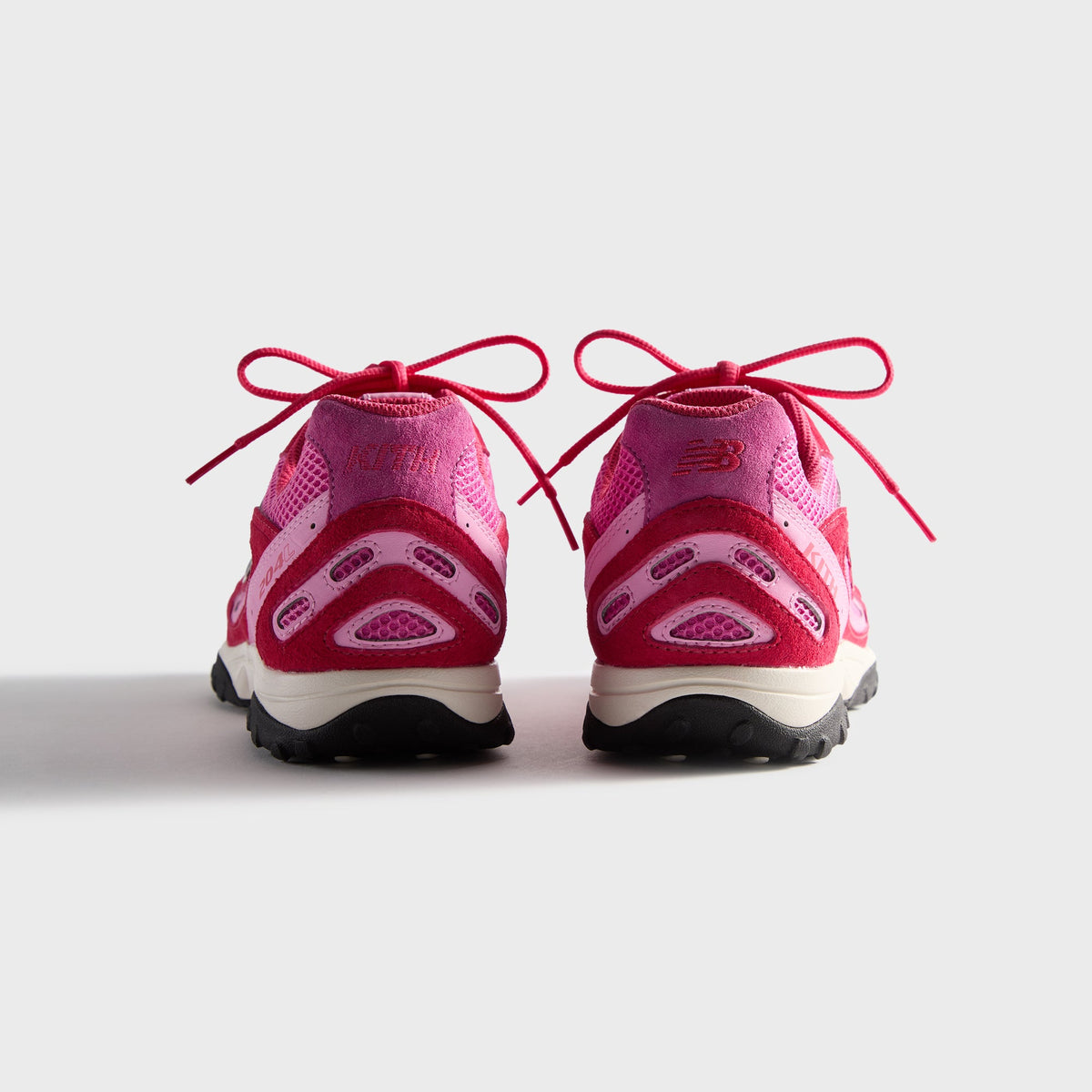 Kith & New Balance 204L in Camellia, rear view of the pink pair showing heel counters and red lace bows