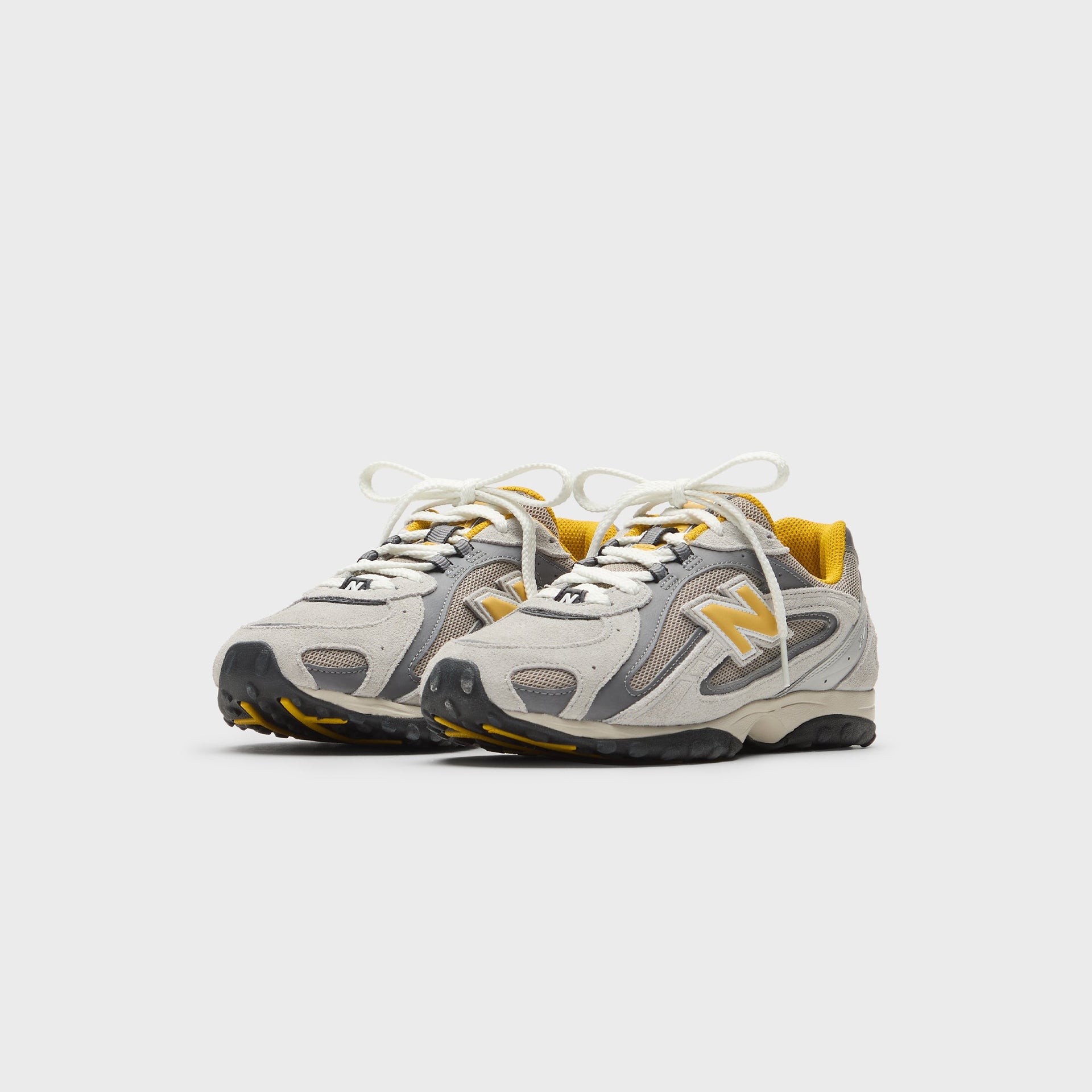 Kith x New Balance 204L sneakers in grey suede and mesh with yellow accents, front three-quarter view