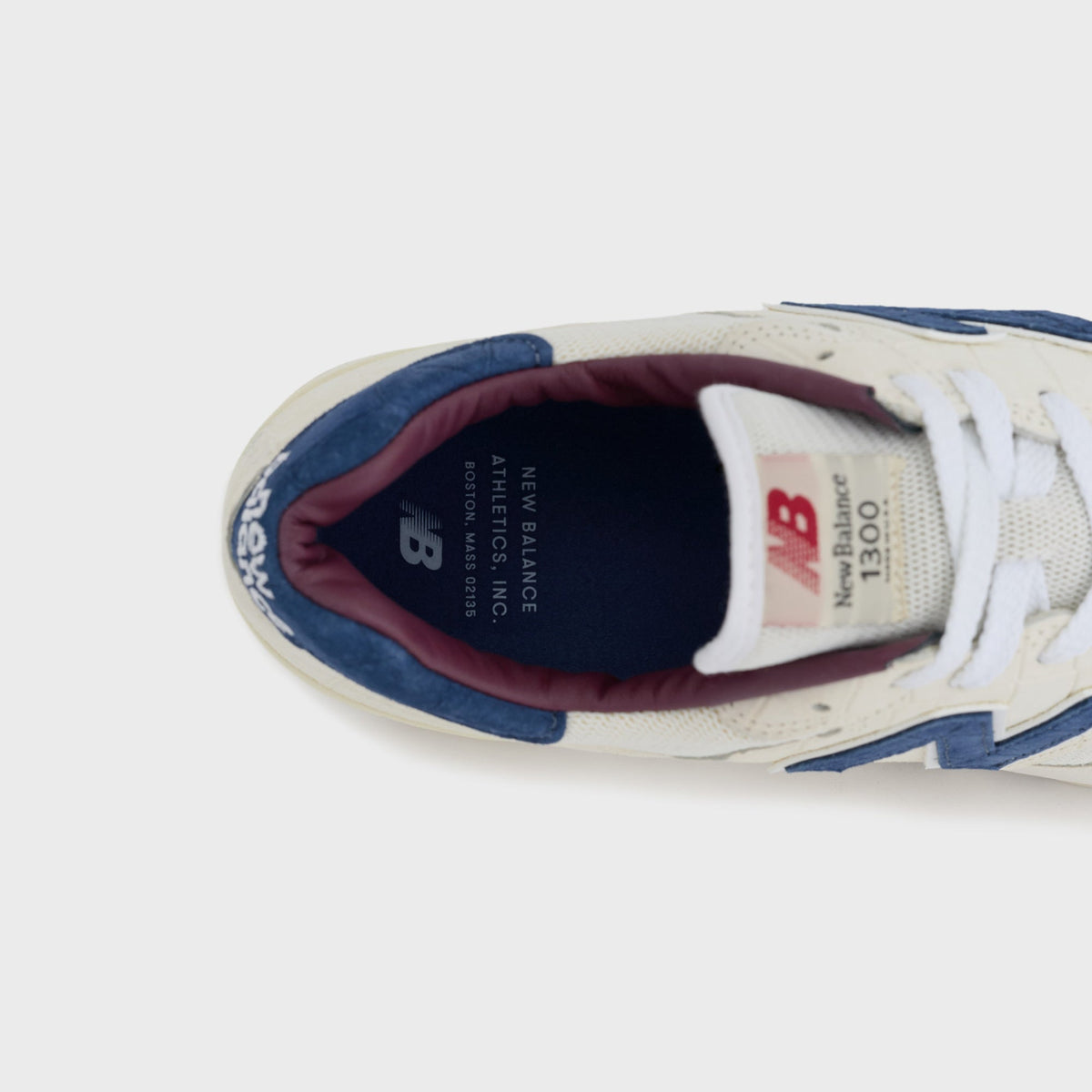 New Balance Made in USA 1300 sneaker, top-down close-up of the tongue label reading New Balance Athletics Inc, Boston Mass