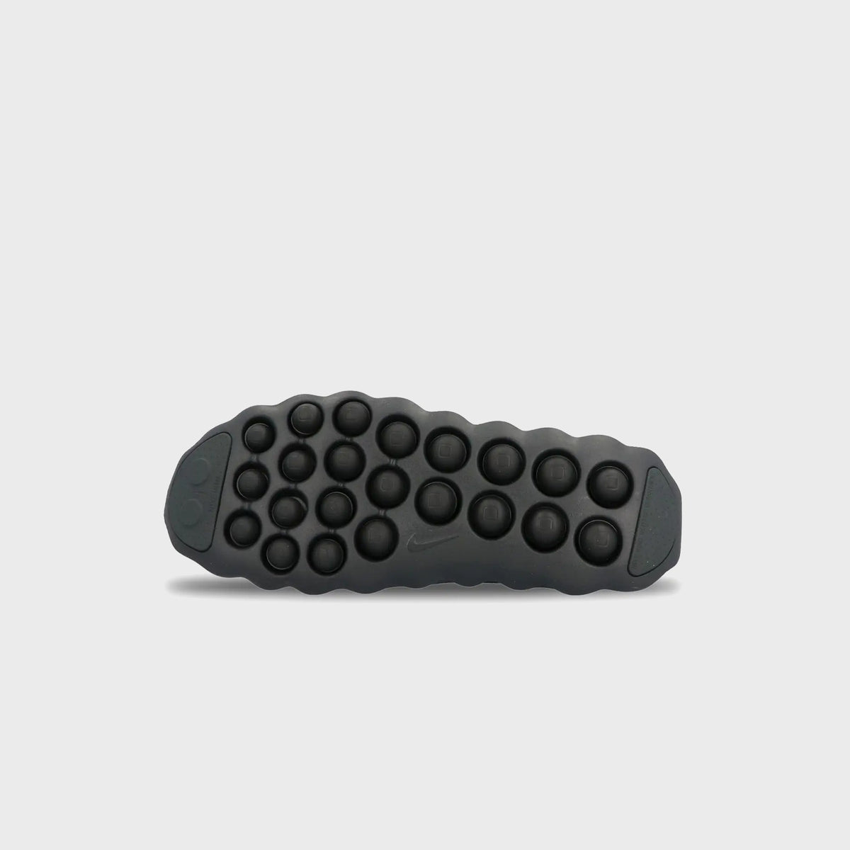 Outsole of Nike Mind 002 Flyknit in black with grid of rounded traction nodes