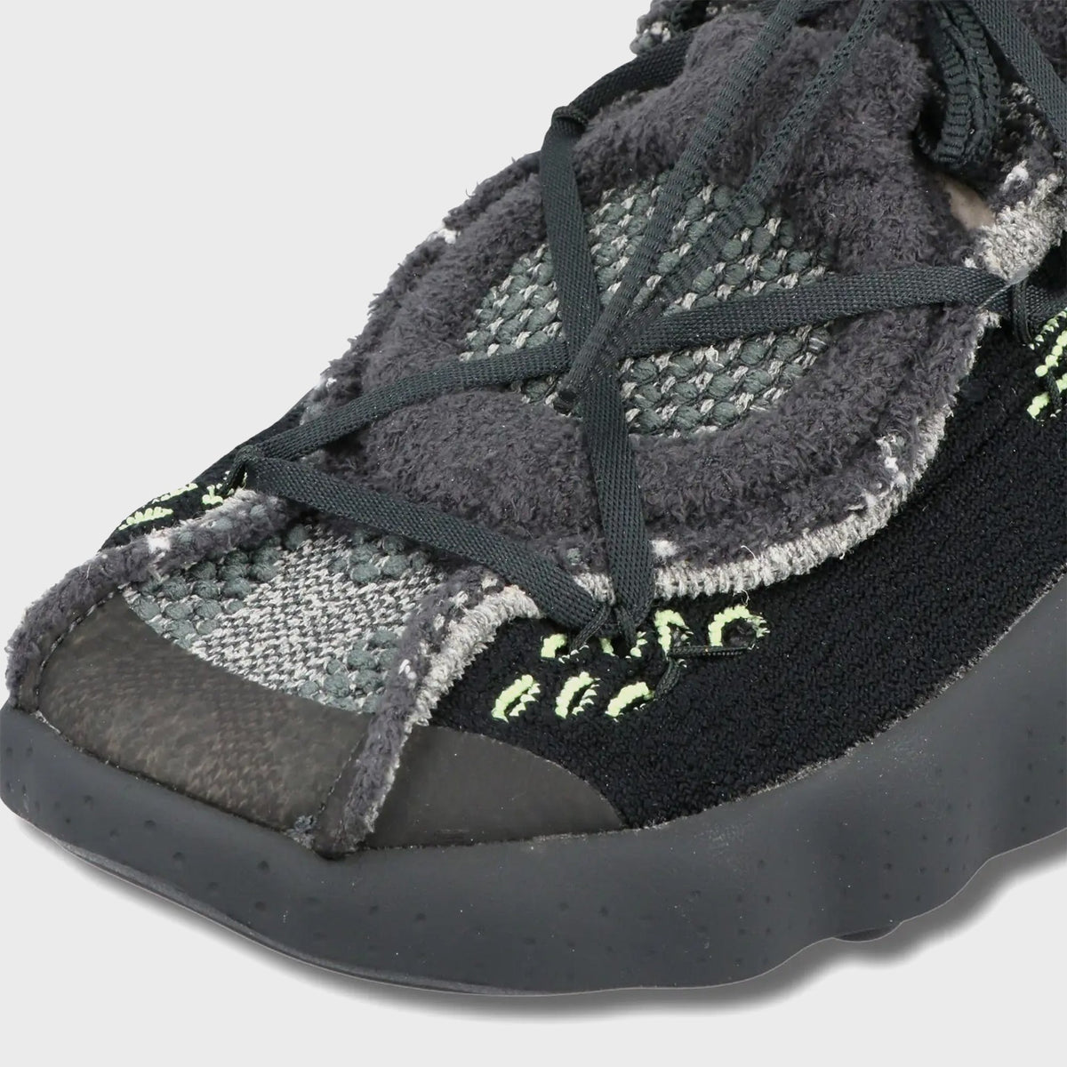 Close-up of Nike Mind 002 Flyknit toe with fuzzy dark grey knit, crossed bungee laces and anthracite sole