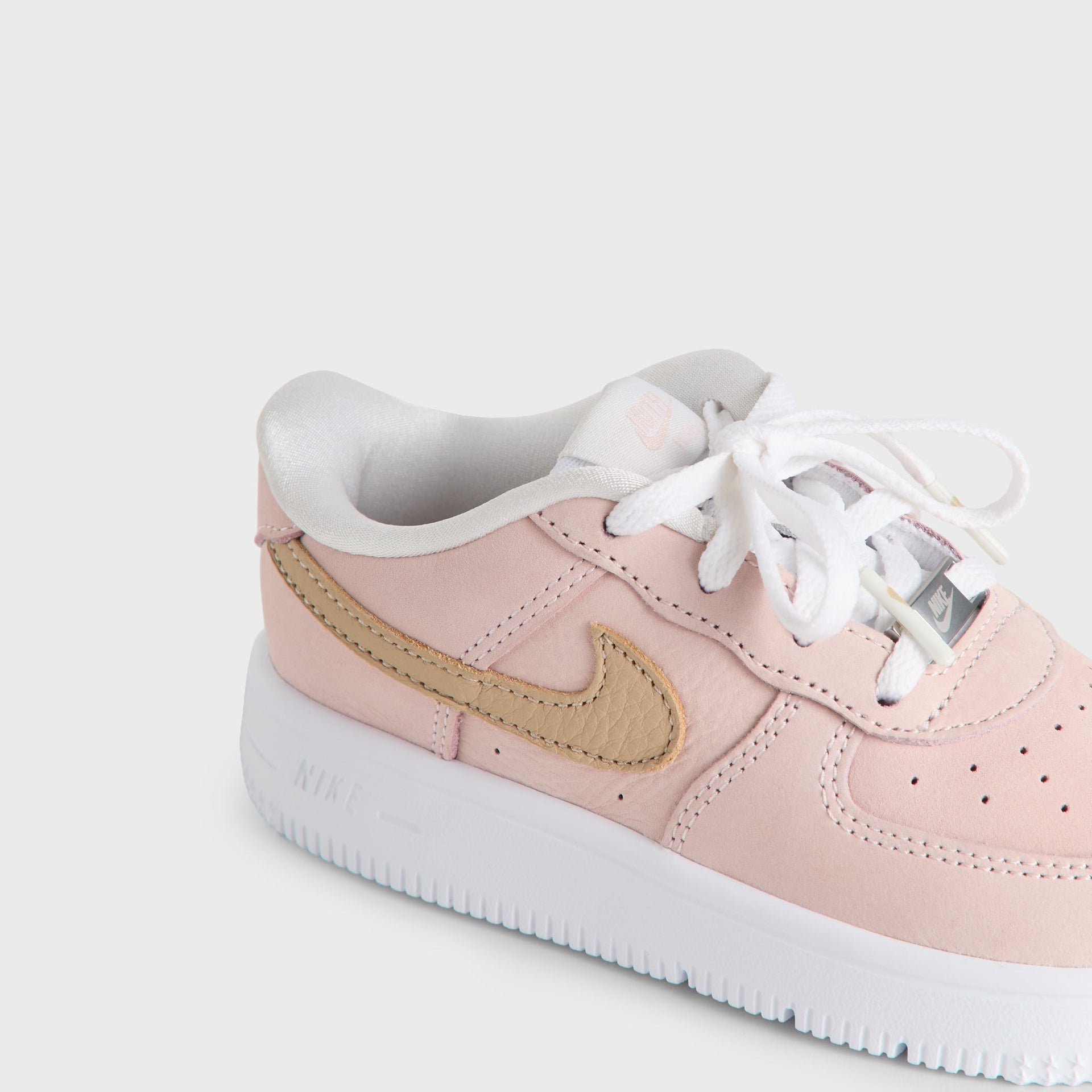 Top-down close-up of the Kith Kids x Nike TD Air Force 1 Un-Linen white laces and perforated pink toe