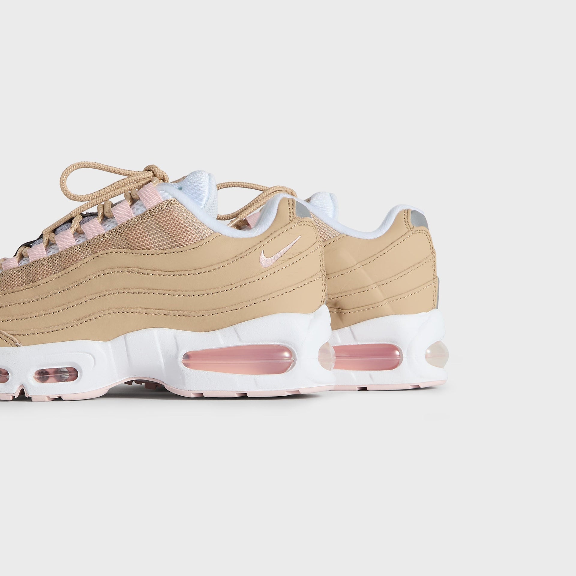 Kith Kids x Nike GS Air Max 95 Linen pair viewed from the heel and outer side, pink Air soles (additional studio view)