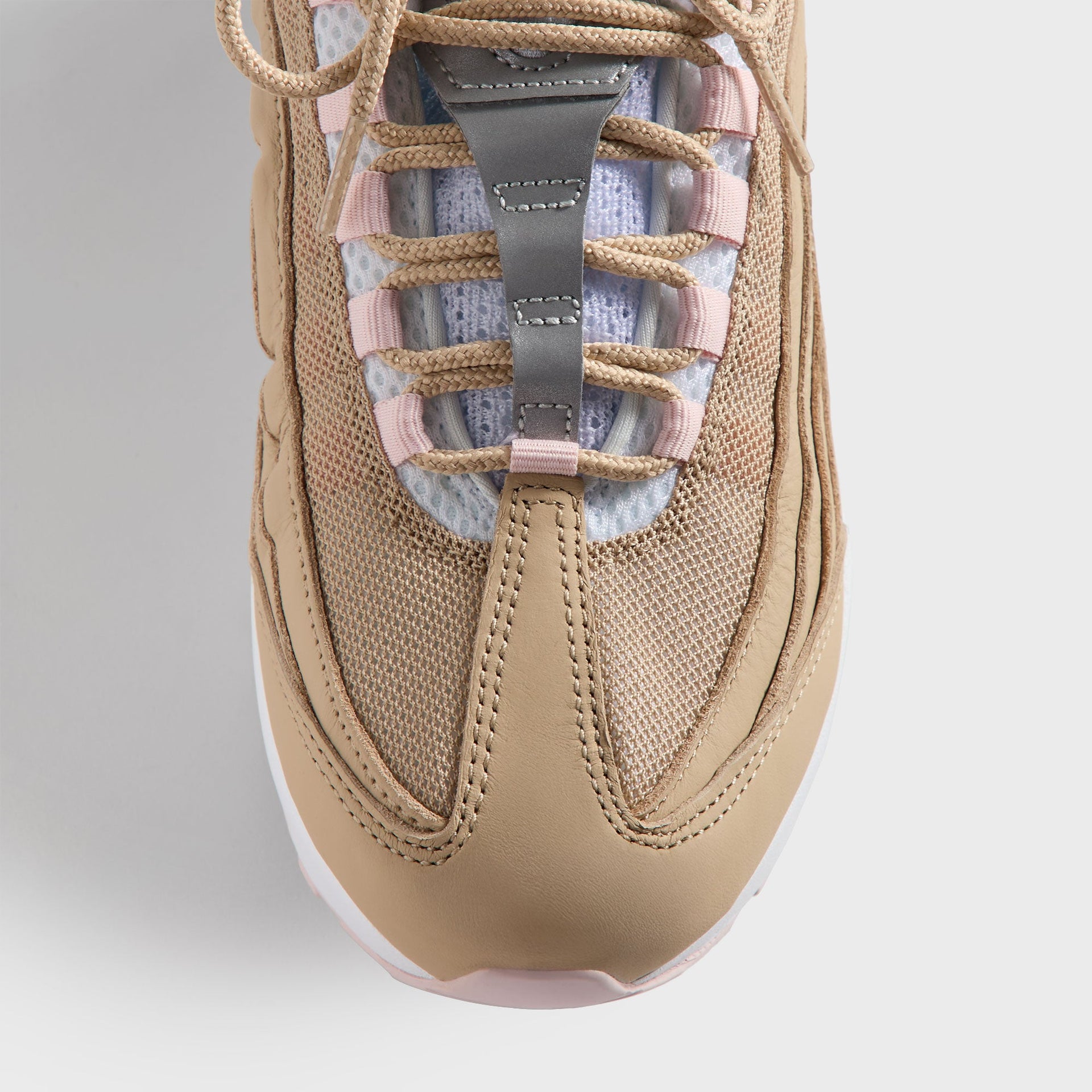 Top-down close-up of the Kith Kids x Nike GS Air Max 95 Linen tongue, pink lace loops and wheat mesh
