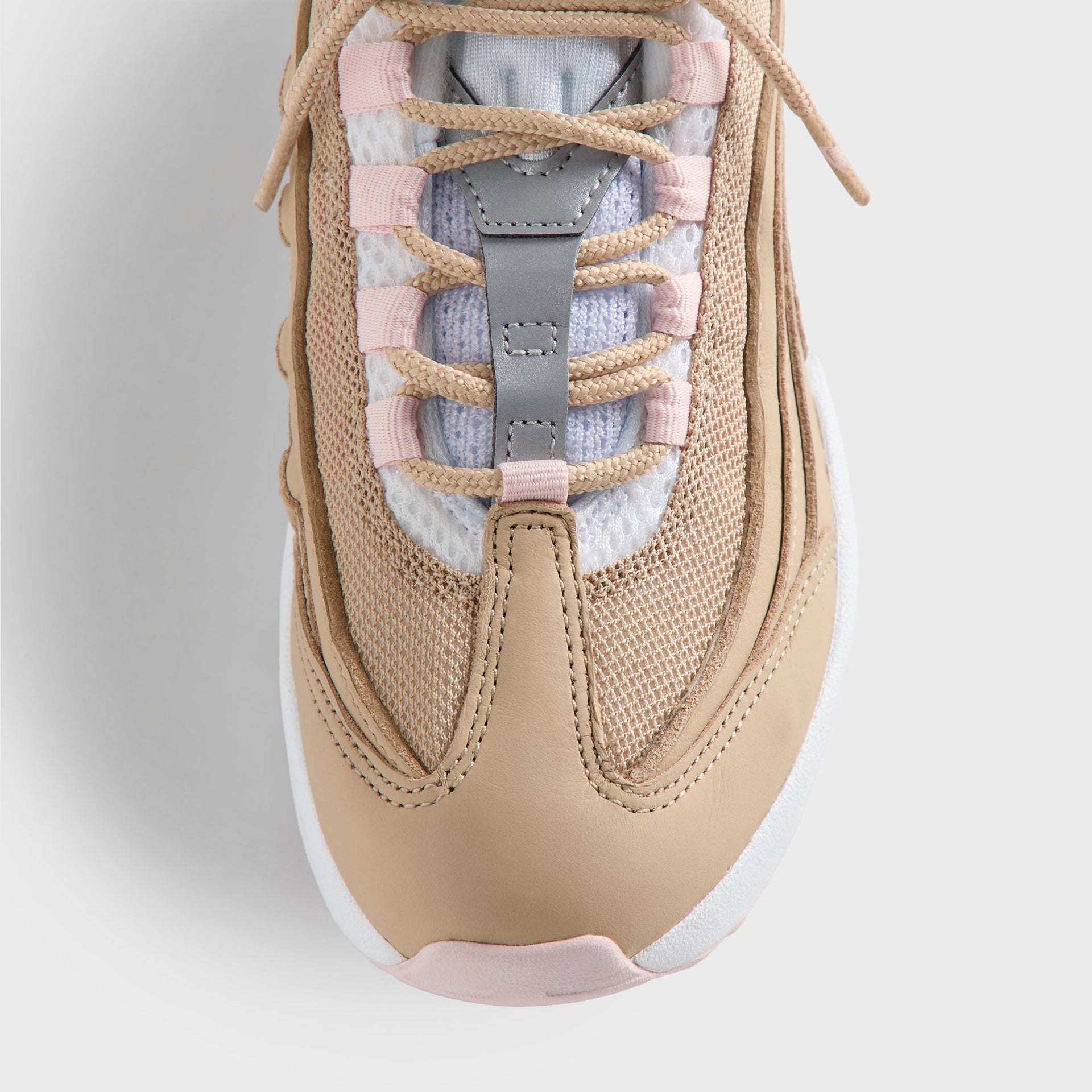 Close-up of the Kith Kids x Nike PS Air Max 95 Linen laced tongue, pink panels and light-blue lining (additional studio view)