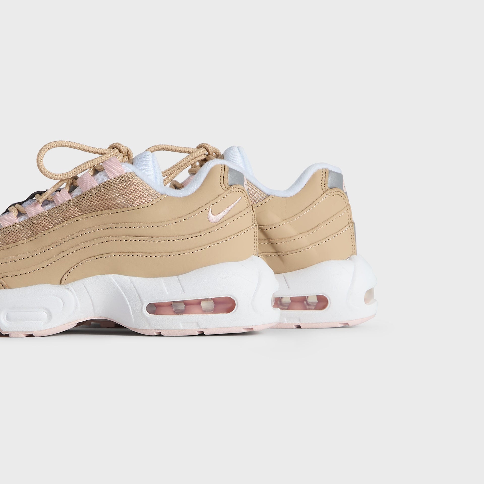 Kith Kids x Nike PS Air Max 95 Linen pair viewed from the heel and outer side, pink Air soles (additional studio view)