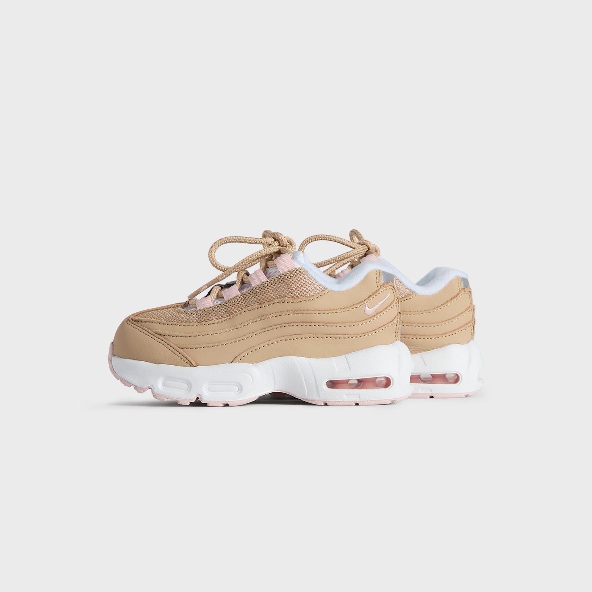 Kith Kids x Nike TD Air Max 95 Linen pair, small front three-quarter angle in wheat linen with pink (additional studio view)
