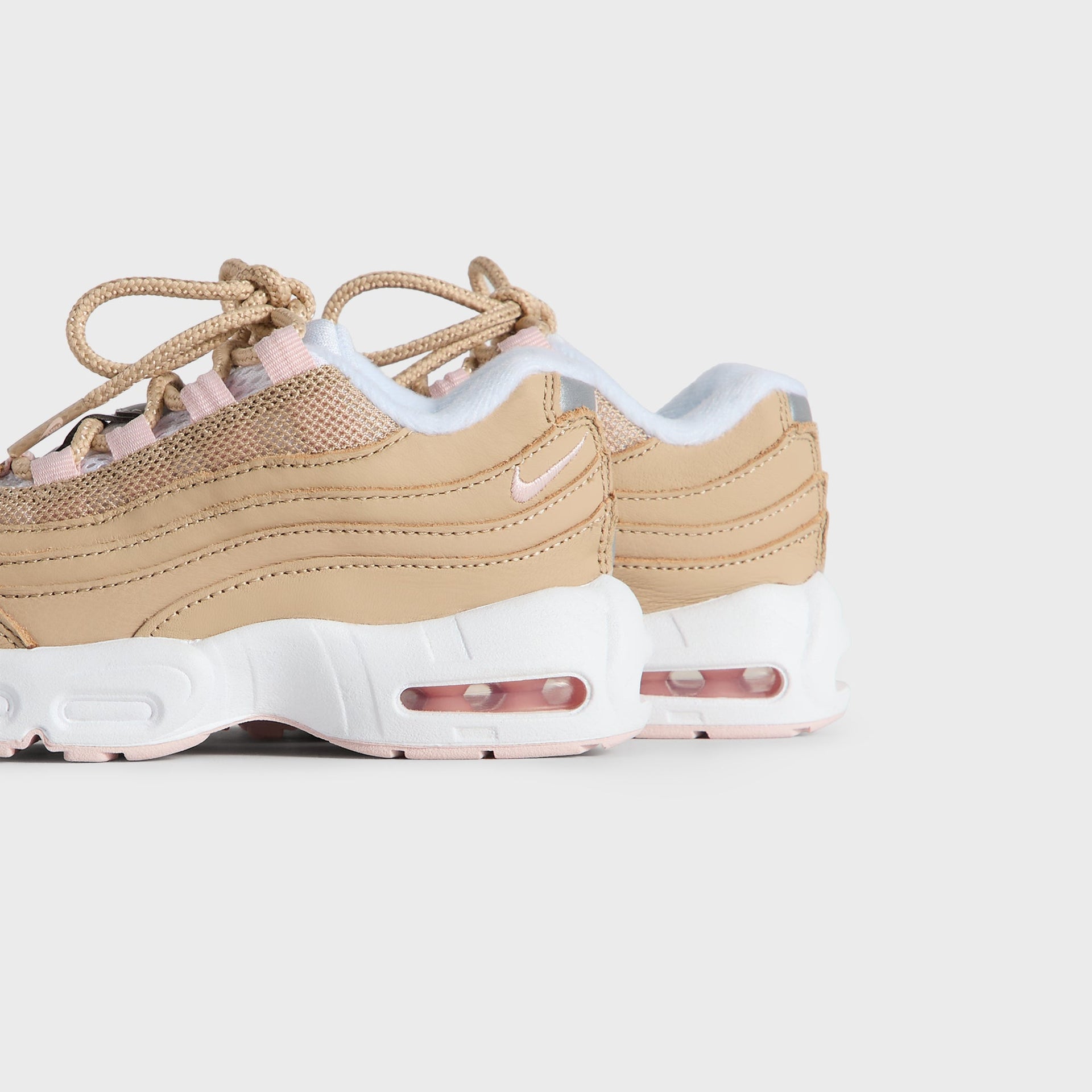 Kith Kids x Nike TD Air Max 95 Linen pair viewed from the heel and outer side, pink Air soles (additional studio view)