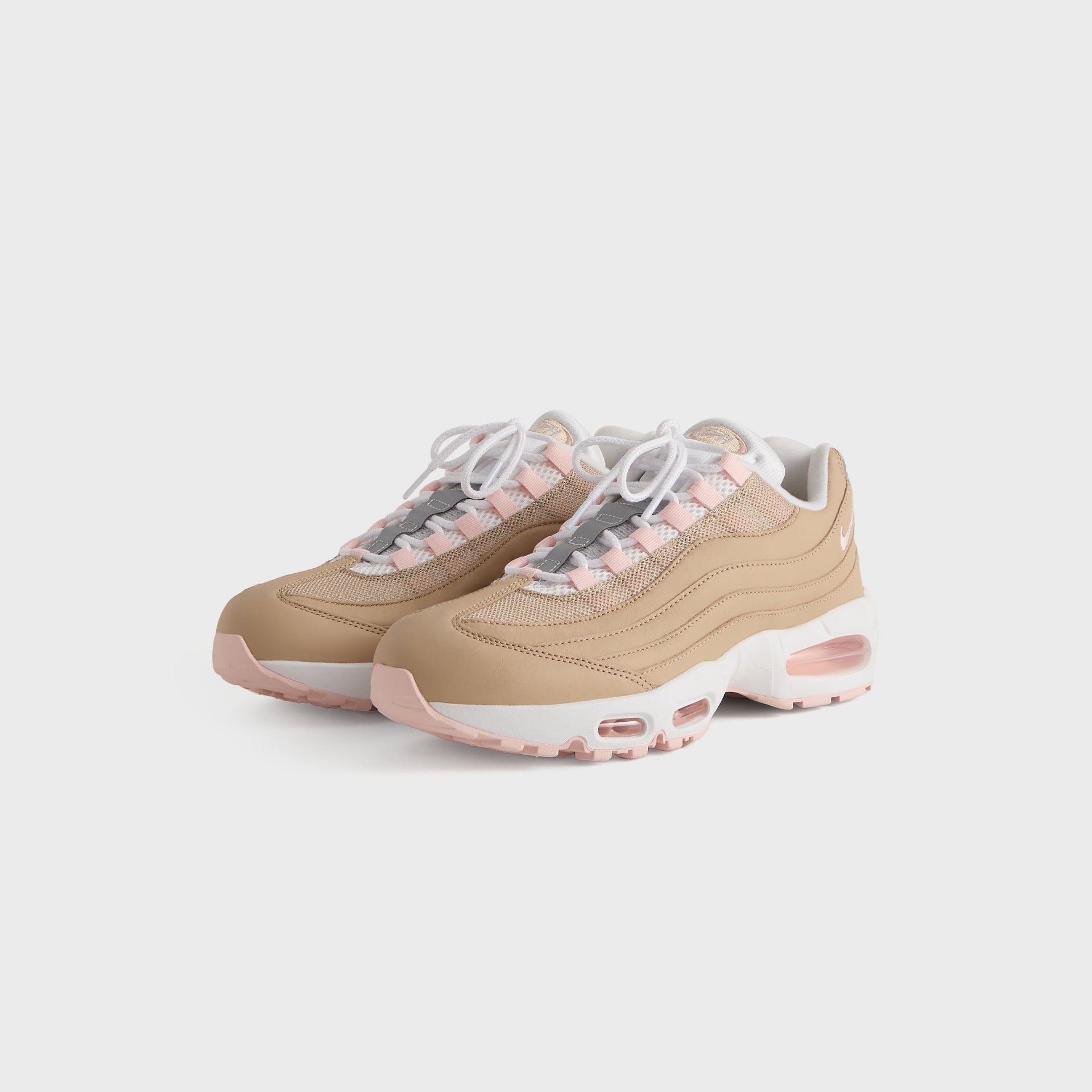 Kith for Nike Air Max 95 'Linen' tan pair at front three-quarter angle with pink and grey lace accents
