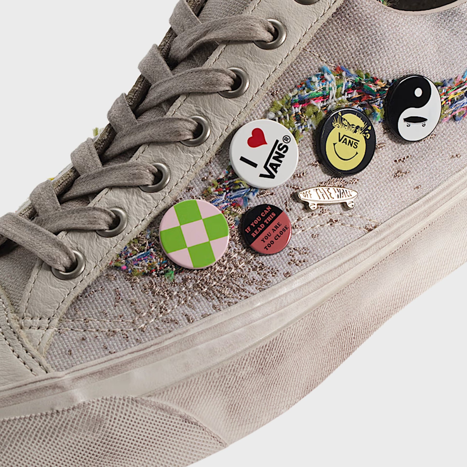 Vans LX Old Skool 36 close-up of the toe and multicolor tweed sidestripe with enamel pins including yin-yang and "I love Vans"